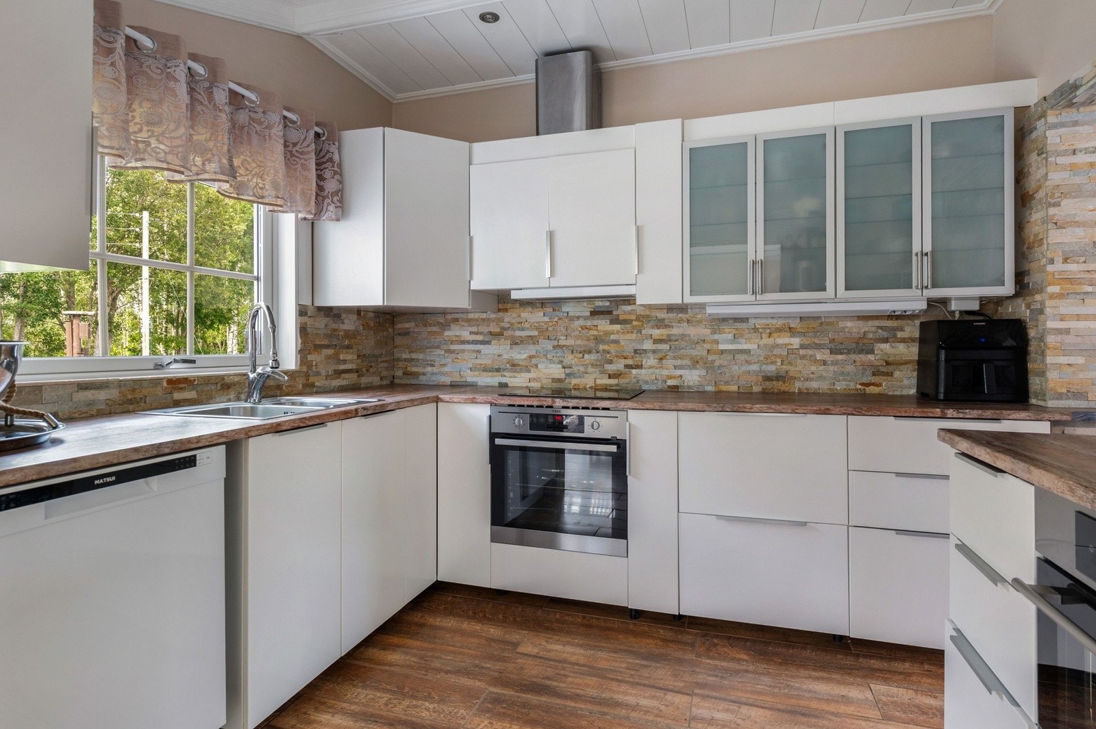 Lys og pen kjøkkeninnredning fra 2020 med god skap- og benkeplass. Galleribilde