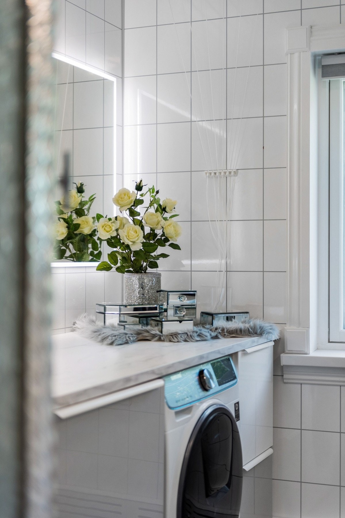 Moderne innredning med skuffer og opplegg for vaskemaskin under laminert benkeplate. Galleribilde