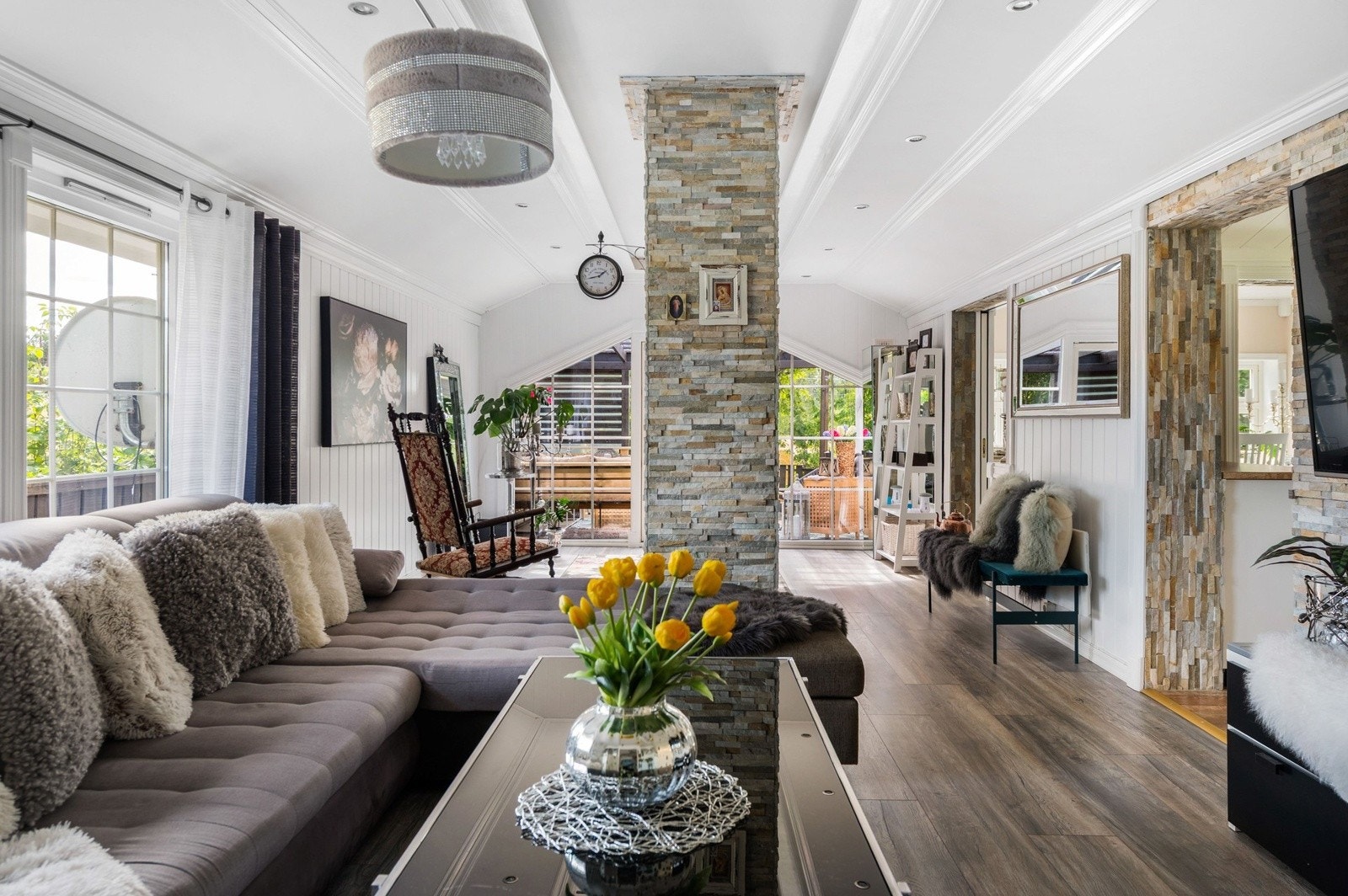 Lys og flott stue med pen enstavs laminat på gulv, lysmalt panel på veggene og downlights i himlingen. Galleribilde