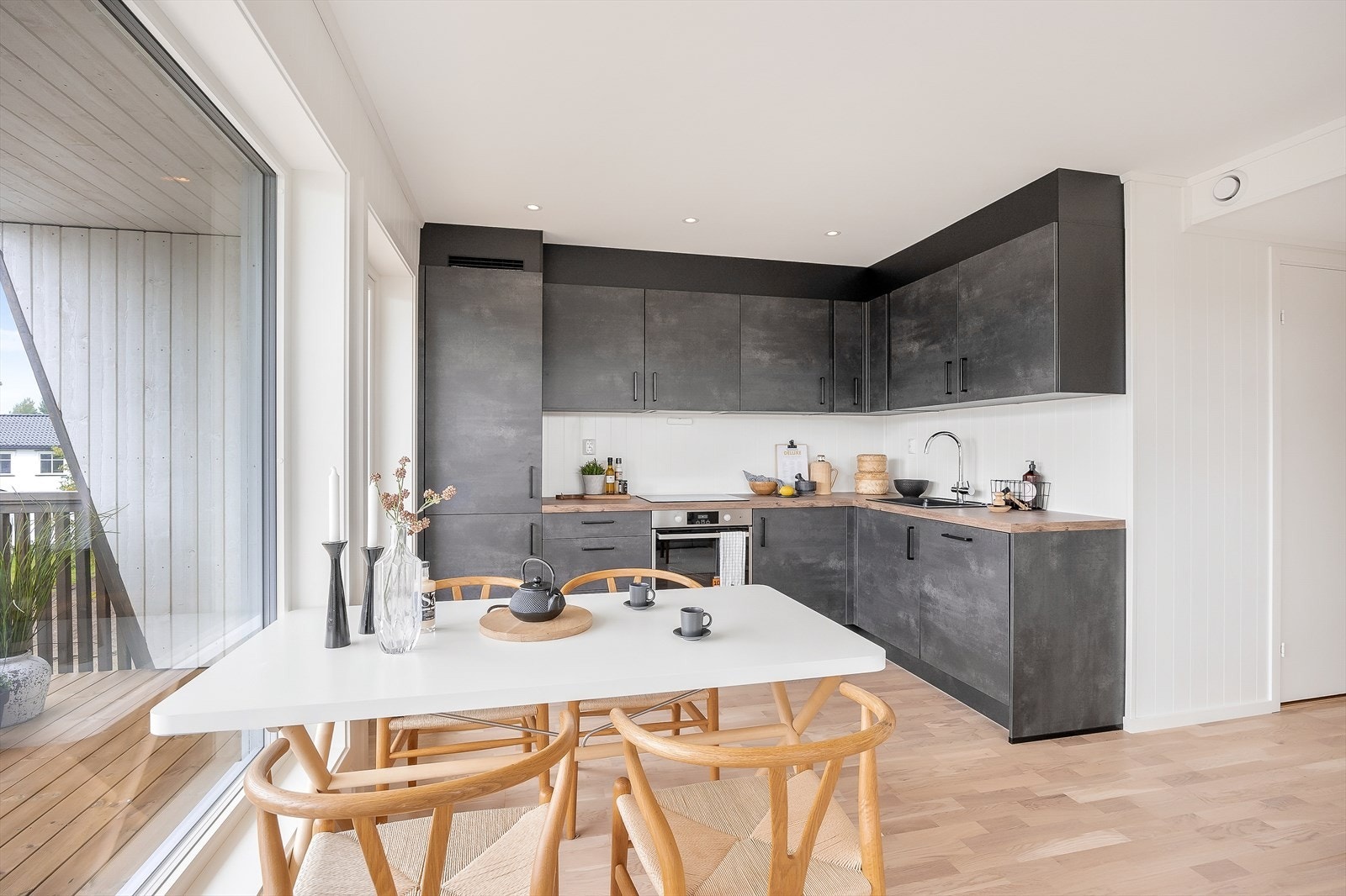 Moderne kjøkkeninnredning med mørke, glatte fronter og laminatbenkeplate. Galleribilde