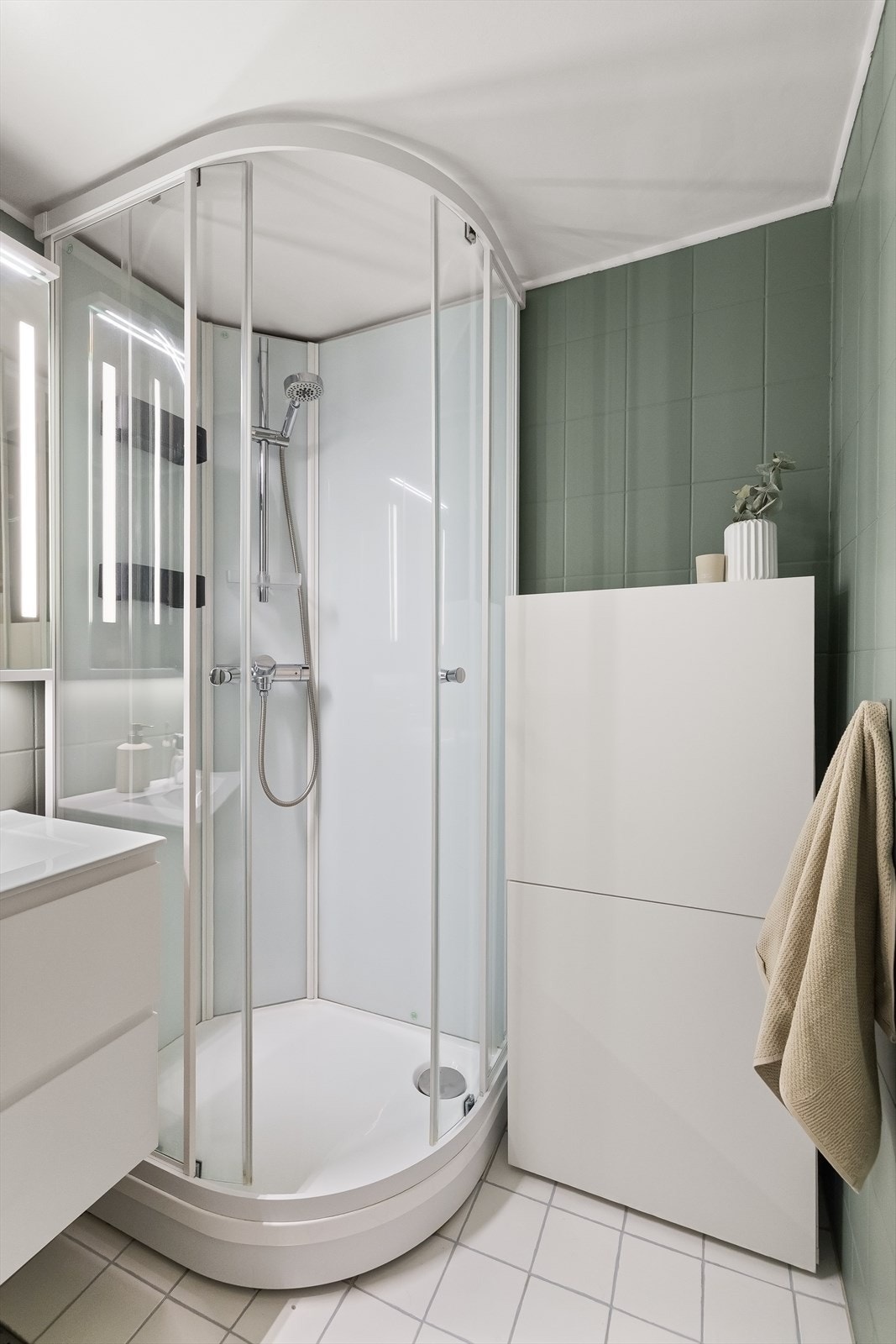 Videre er badet innredet med gulvstående toalett og dusjkabinett med hånddusj Galleribilde