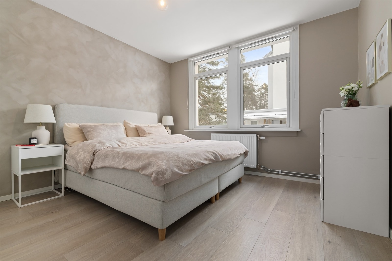 Lyst og romslig hovedsoverom med god plass til både dobbeltseng og tilhørende nattbord Galleribilde