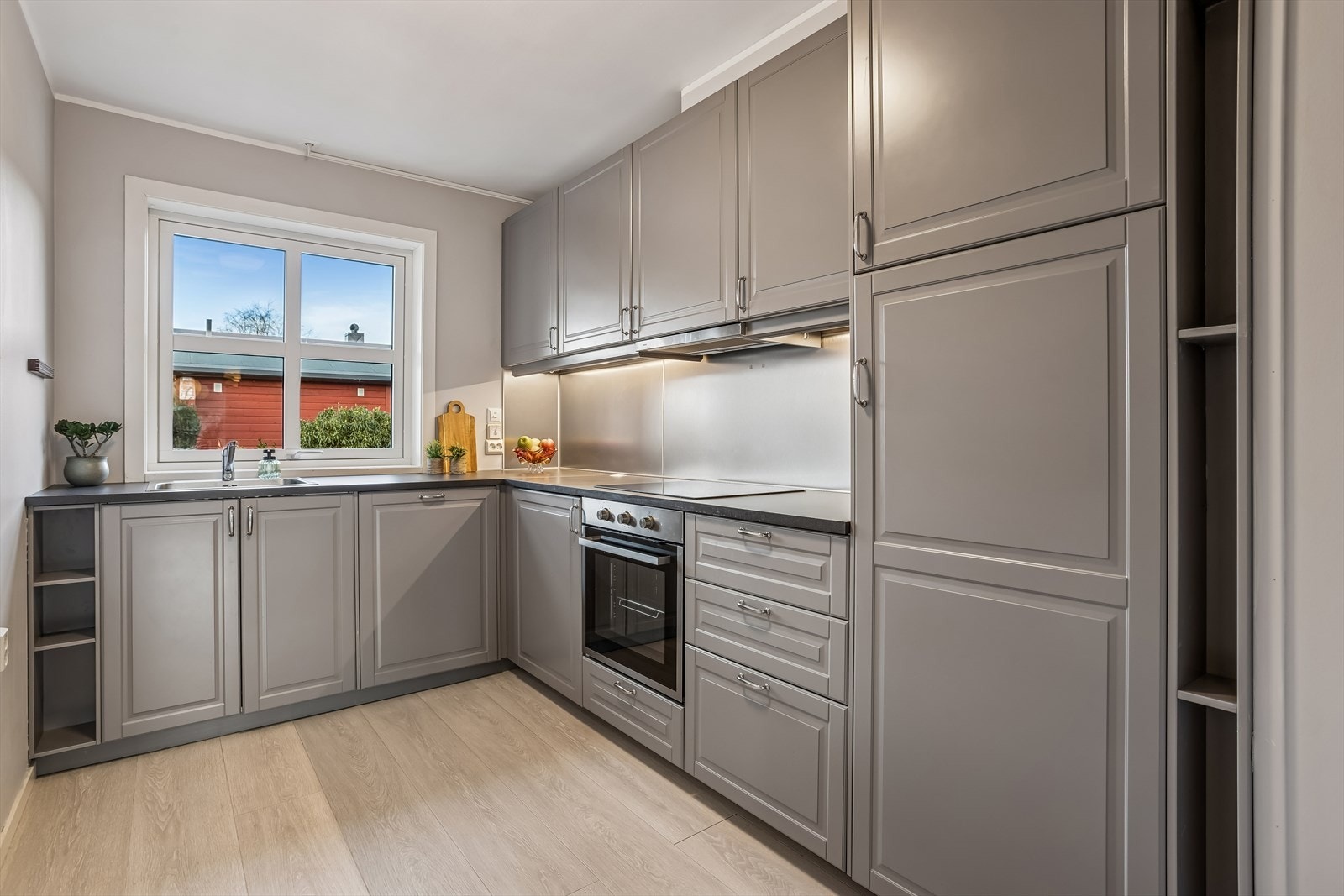 Separat kjøkken med langstrakt benkeplate, moderne utstyrt med integrerte hvitevarer og god oppbevaringsplass. Galleribilde