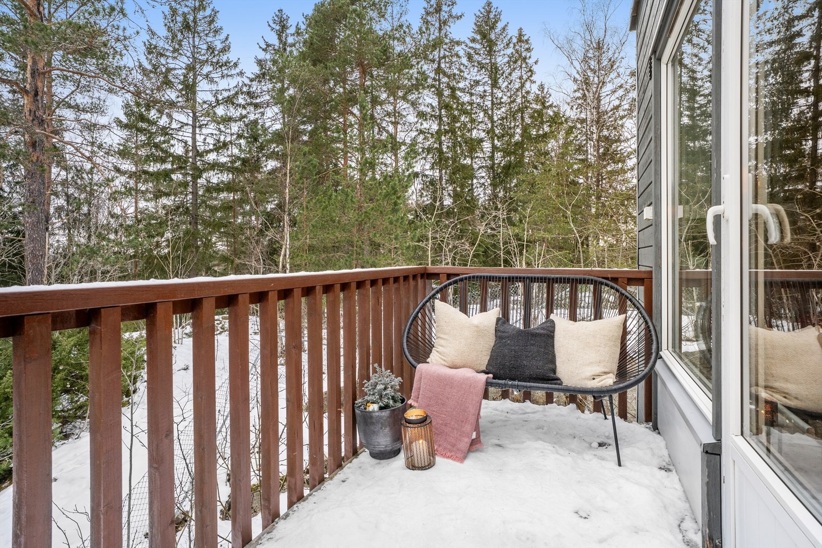 Balkongen har utsikt ut mot skogen. Galleribilde