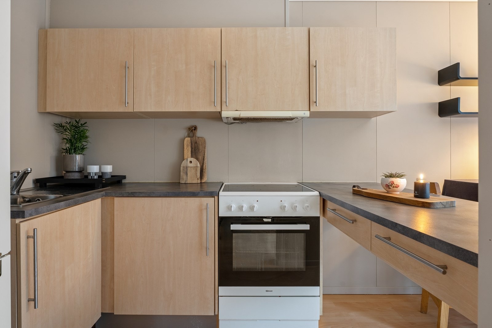 Kjøkkenet er utstyrt med frittstående komfyr og avsatt plass til kjøleskap.
Ventilator plassert over komfyr med avtrekk ut. Galleribilde