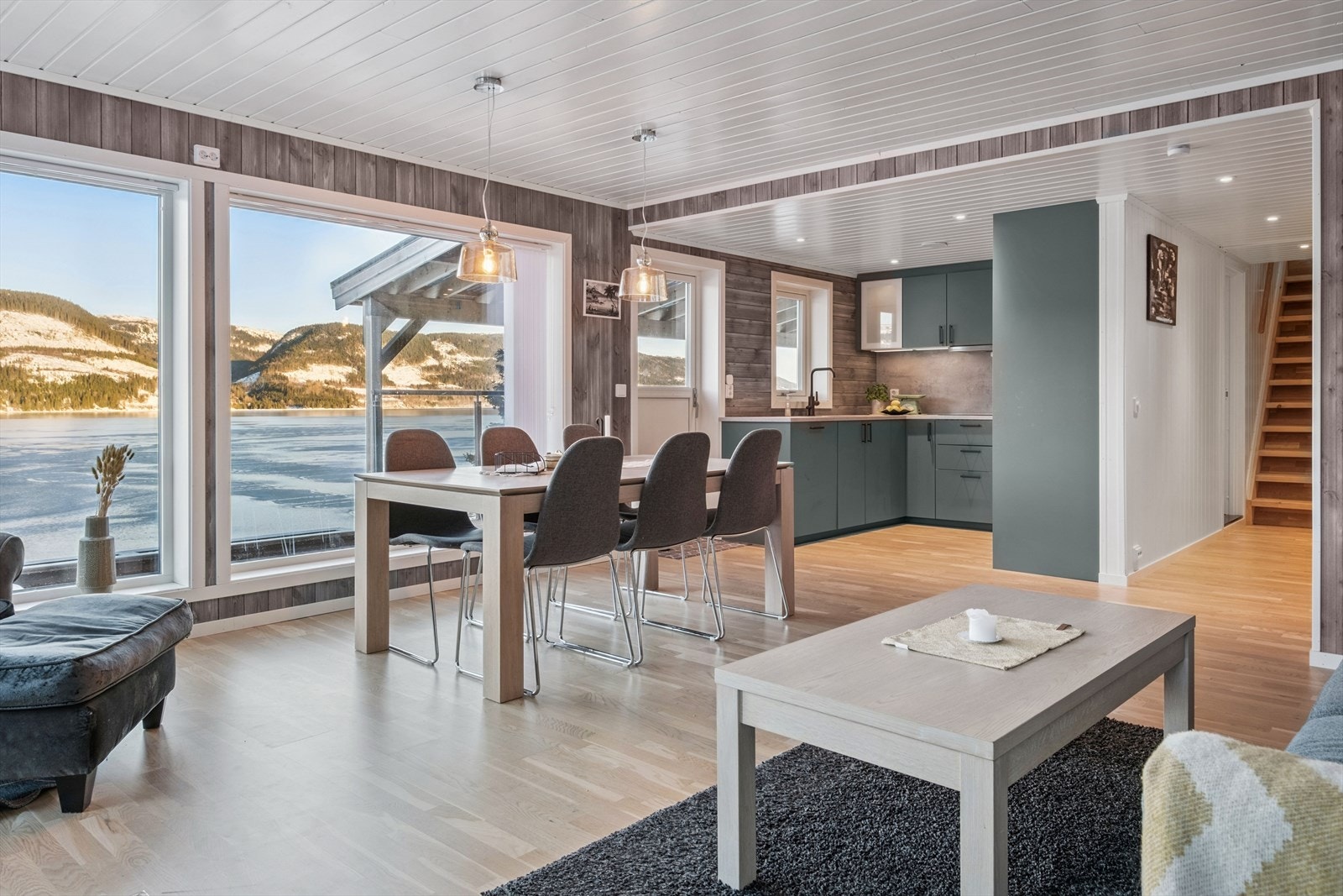 Romslig stue med store vindusflater som rammer inn utsikten på elegant vis. Galleribilde