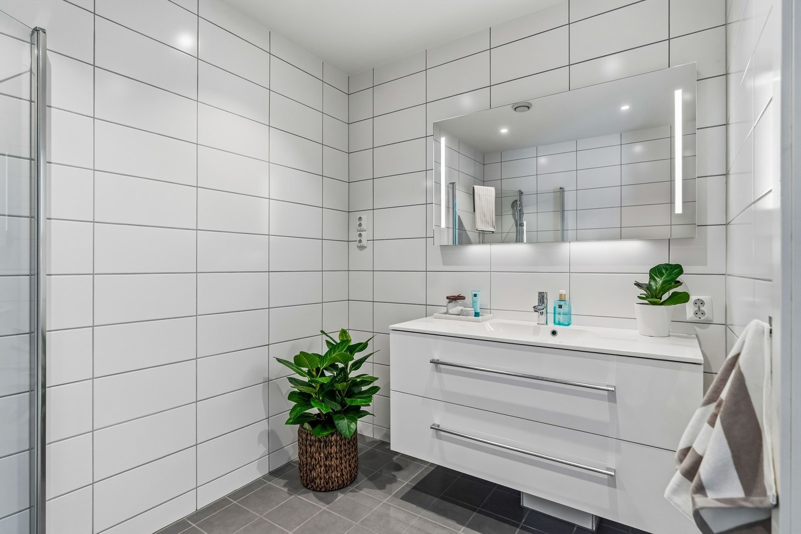 Det er dusjhjørne, toalett og baderomsmøbel med speil. Galleribilde