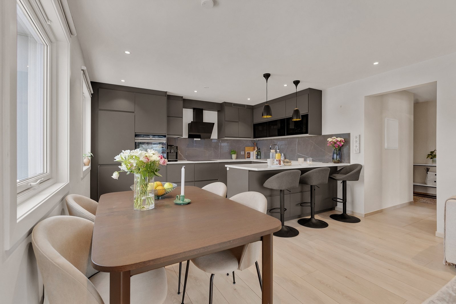 Romslig og stilrent kjøkken i åpen løsning mot stue, med god skap- og benkeplass samt naturlig plass for spisebord. Galleribilde