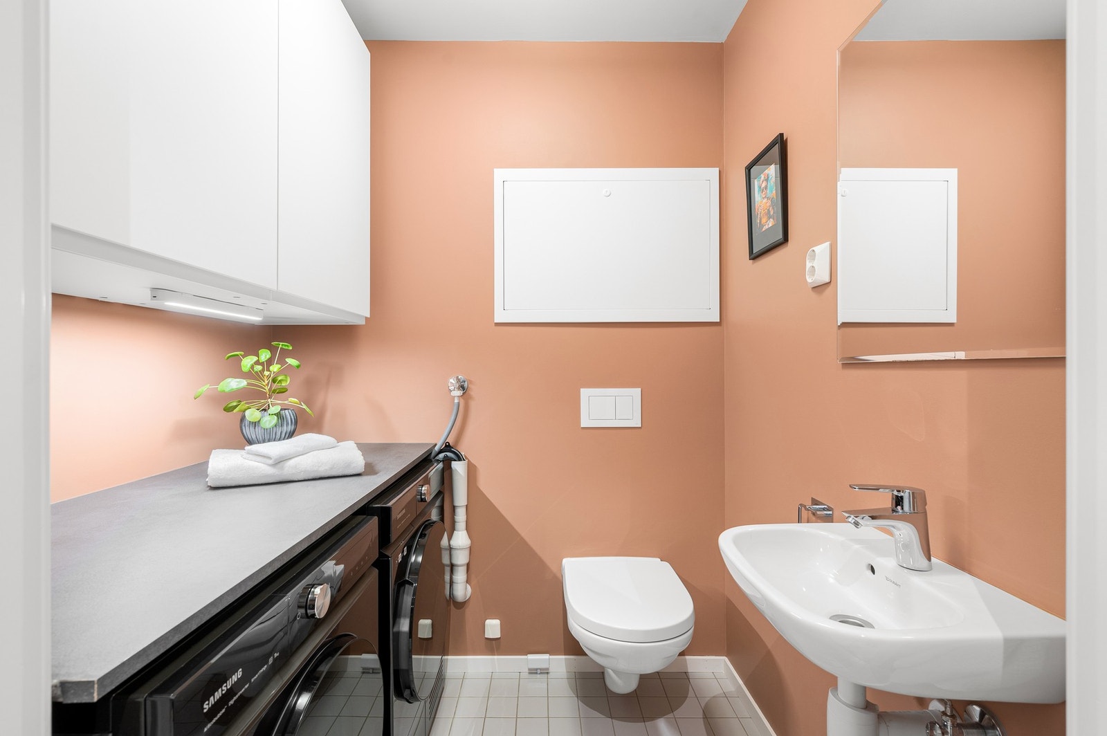 Praktisk bad/vaskerom med toalett, opplegg for vaskemaskin, god oppbevaringsplass samt vegghengt innredning. Galleribilde