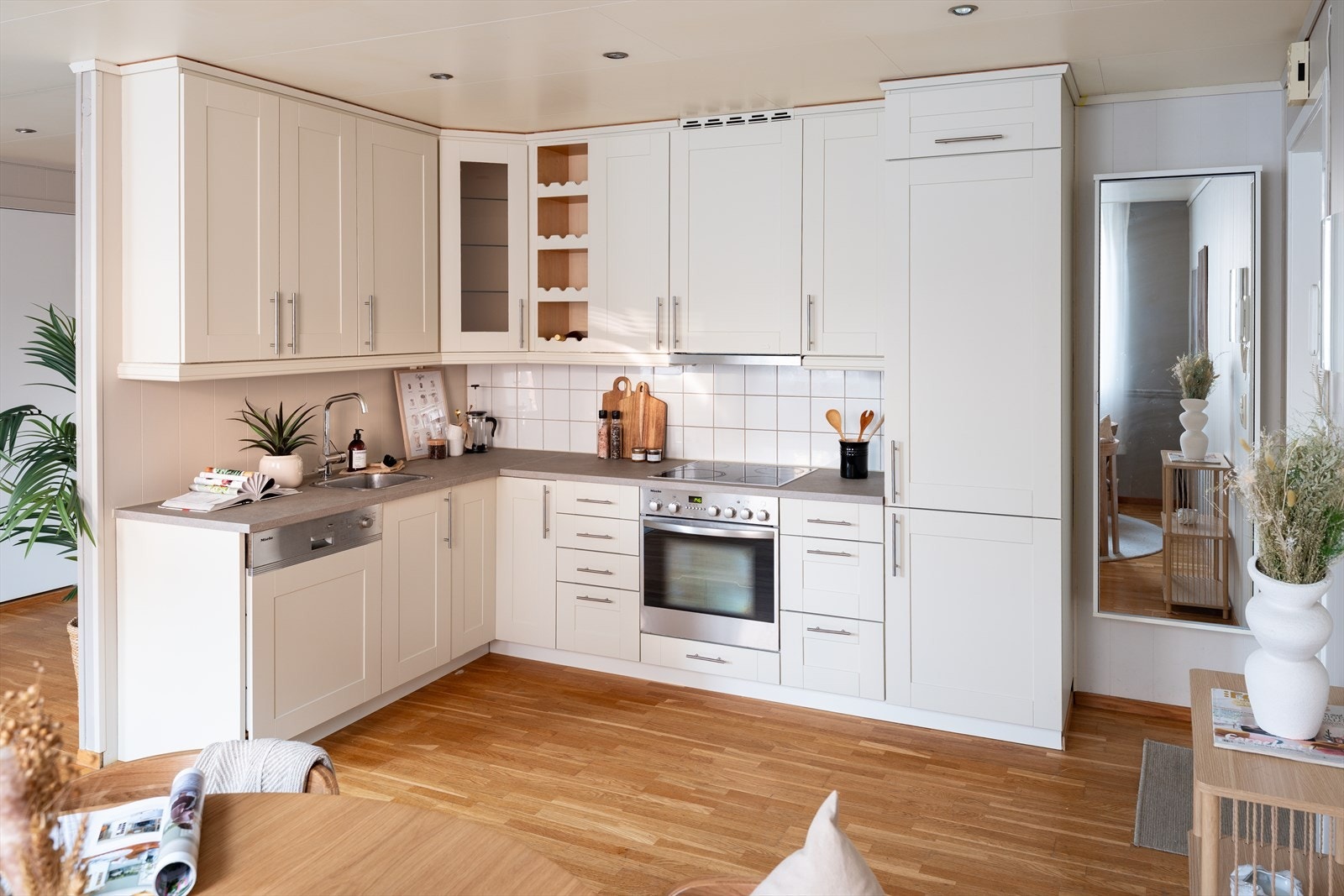 Kjøkken i L-form og fronter i klassisk utførelse. L-form er mer praktisk enn man ofte tenker, og gir gode arbeidsflater. Profilerte kjøkkenfronter er tidløst og gir rommet en innbydende atmosfære. Galleribilde