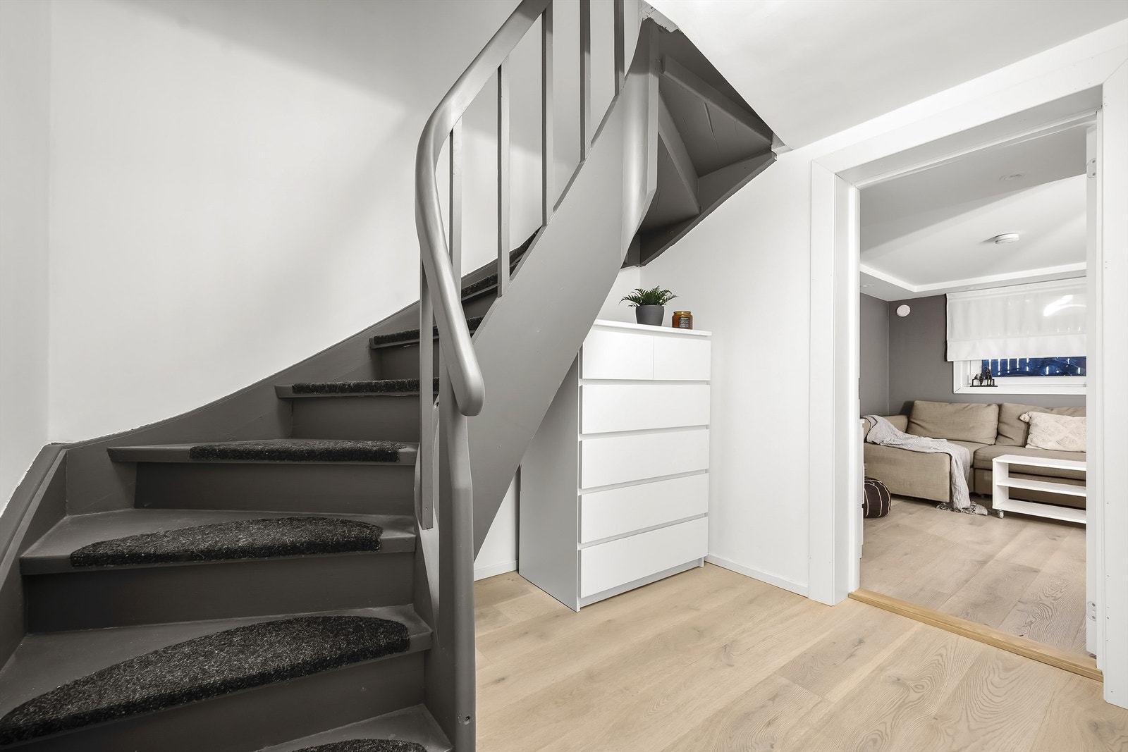 Vi går ned i underetasjen. Her finner du en romslig gang med plass til oppbevaring under trappen, bad 2, kjellerstue og bod. Galleribilde