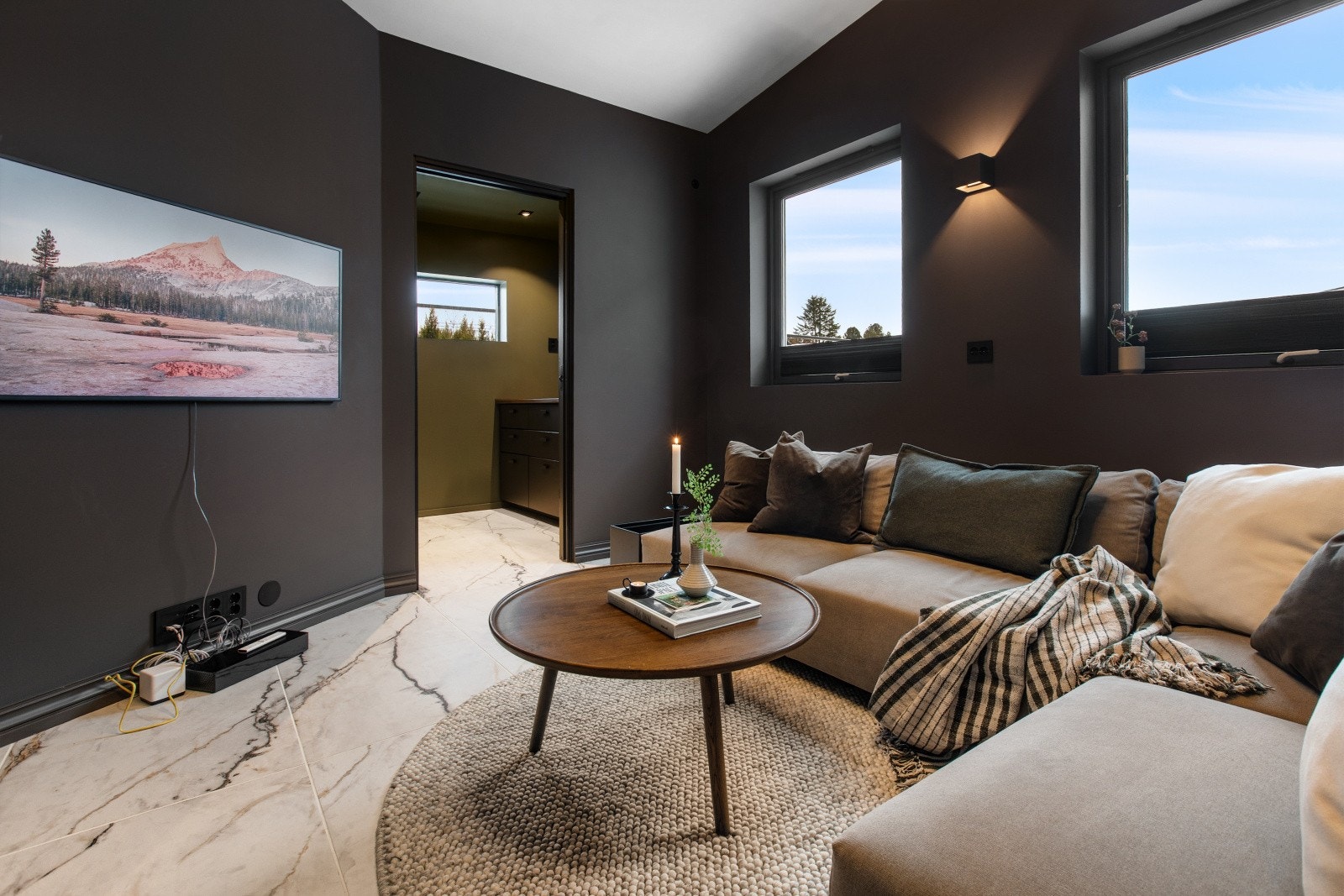 Stuen har plass til stor sofagruppe og innerst i rommet er det en praktisk bod med innredning. Galleribilde