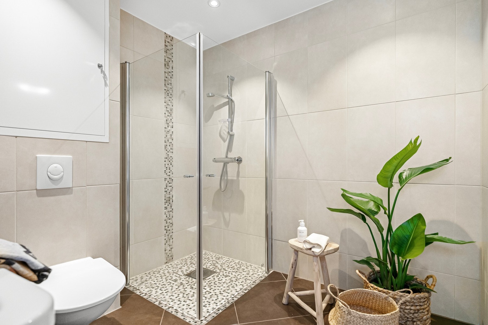 Flislagt i lyse beige toner på vegger og mørkere fliser på gulv. Galleribilde