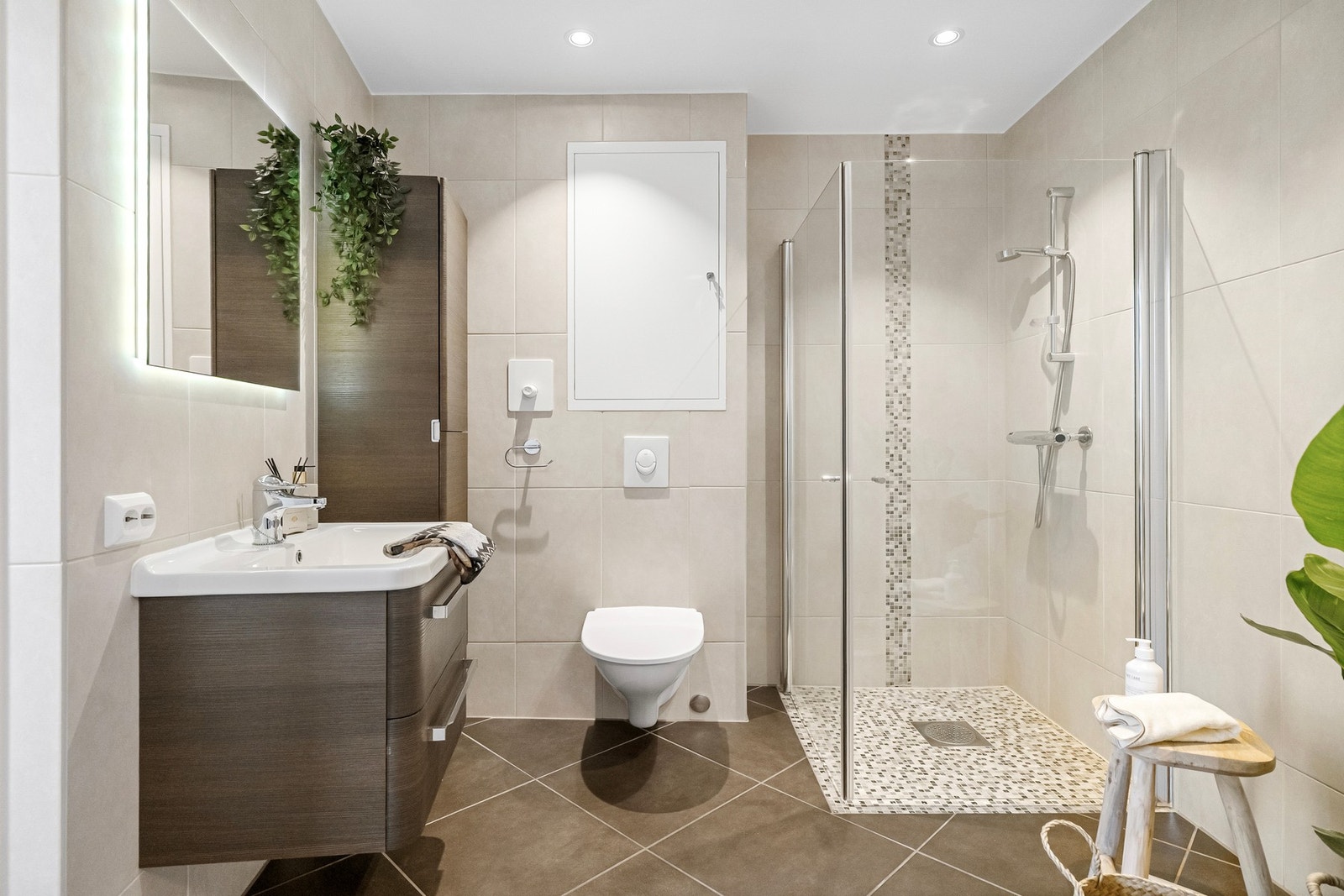 Innredningen består av heldekkende servant, vegghengt skap, speil med integrert belysning samt dusjhjørne. Galleribilde