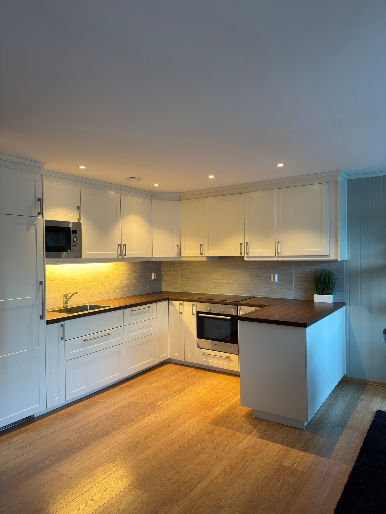 Kjøkkenet har behagelig farge på frontene og benkeplaten. Galleribilde