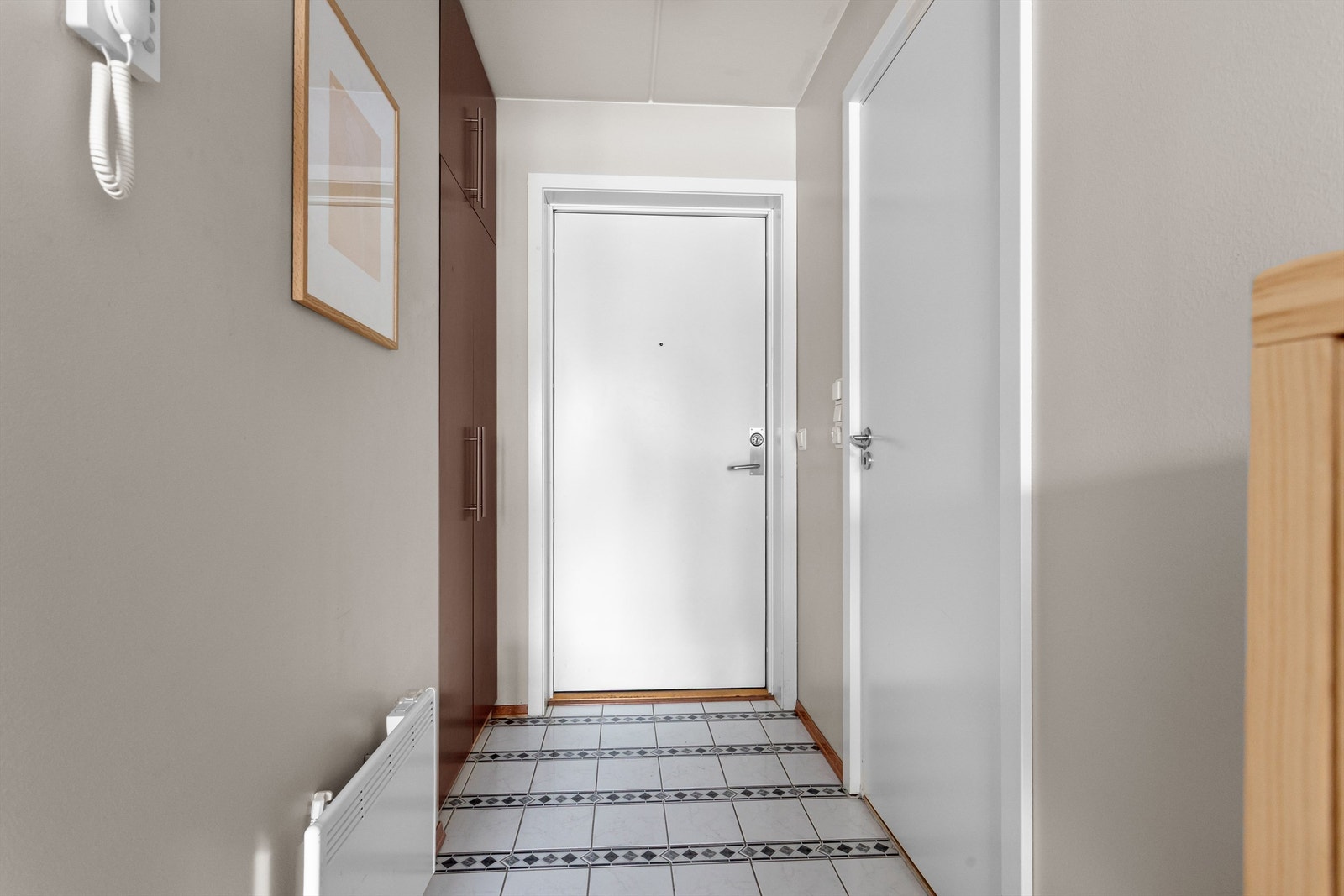 Velkommen inn! Entréen har lyse og delikate overflater på vegger og himling, flislagt gulv og ytterdøren er både lyd- og brannklassifisert. Galleribilde