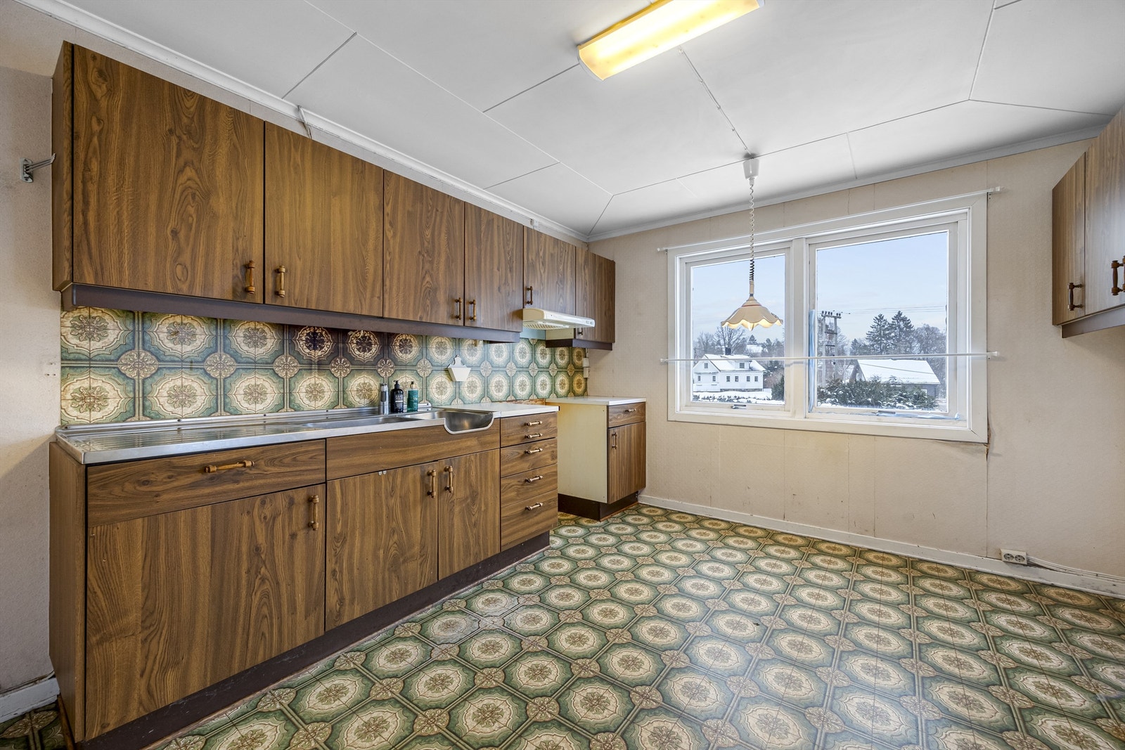 Kjøkkenet i første etasje har en eldre innredning med glatte fronter. Galleribilde