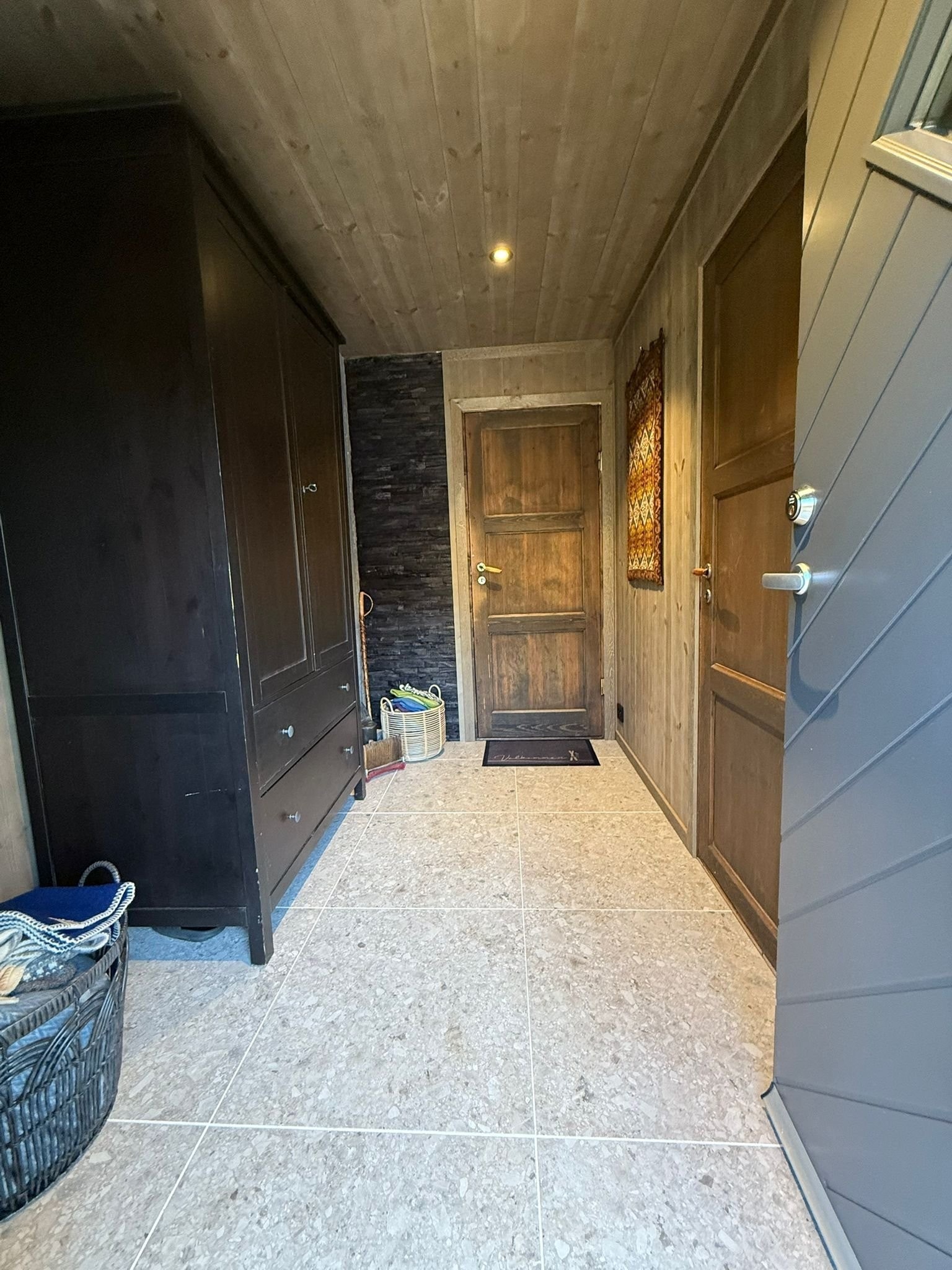 Flislagt gang med god plass til oppbevaring. Soverom 1 ligger til høyre og er avskjermet fra stue med dør til stuen. Galleribilde