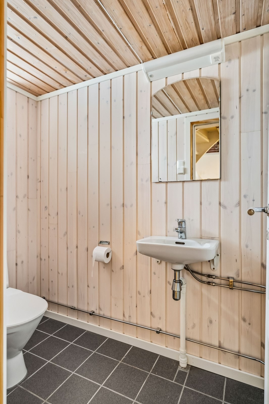 I kjelleren er wc-rommet innredet med panelvegger, varmekabler og flislagt gulv. Galleribilde