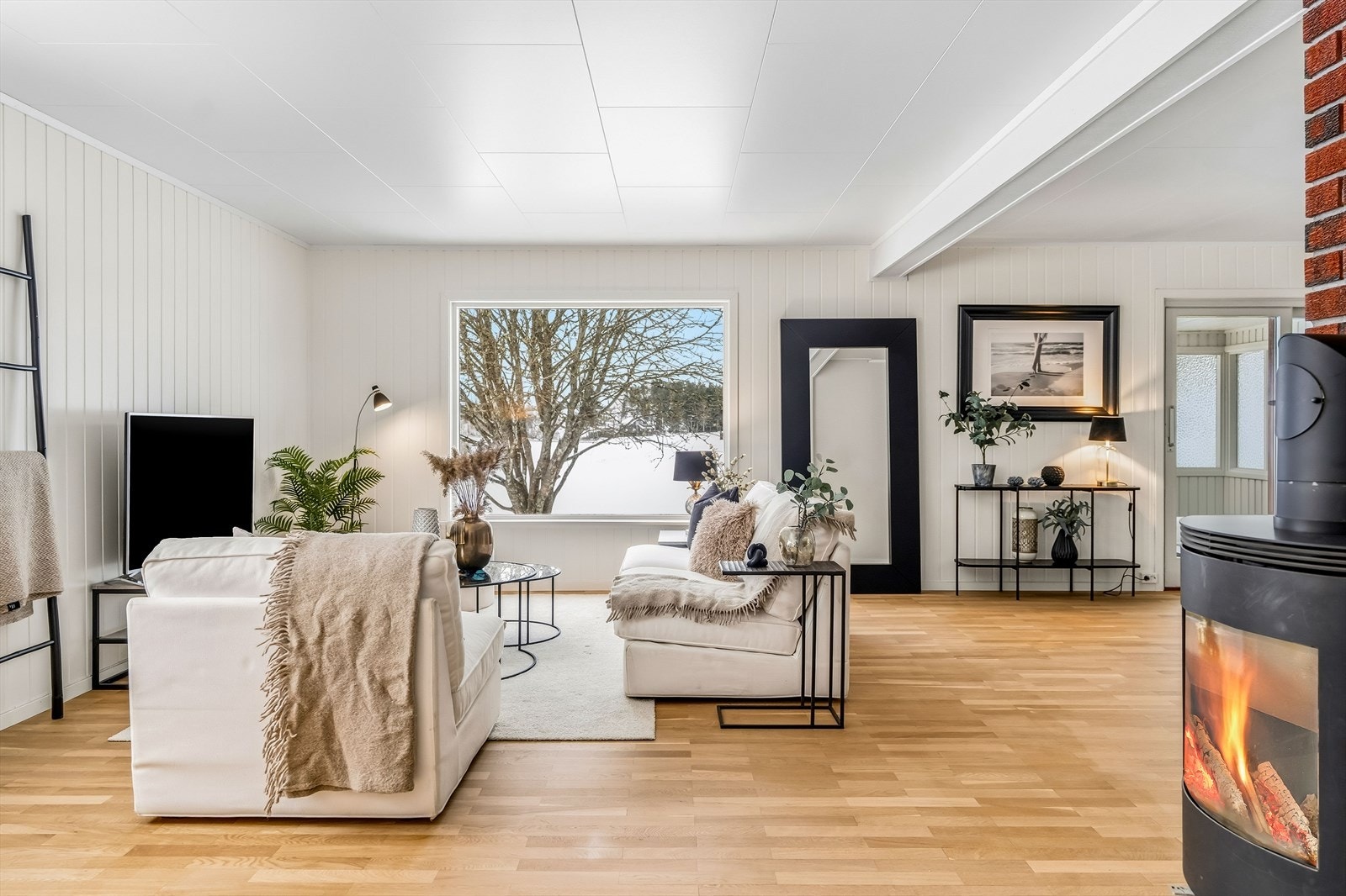 De store vinduene slipper inn litt av det grønne, og inkluderer en skyvedør fra 2020 til verandaen. Galleribilde