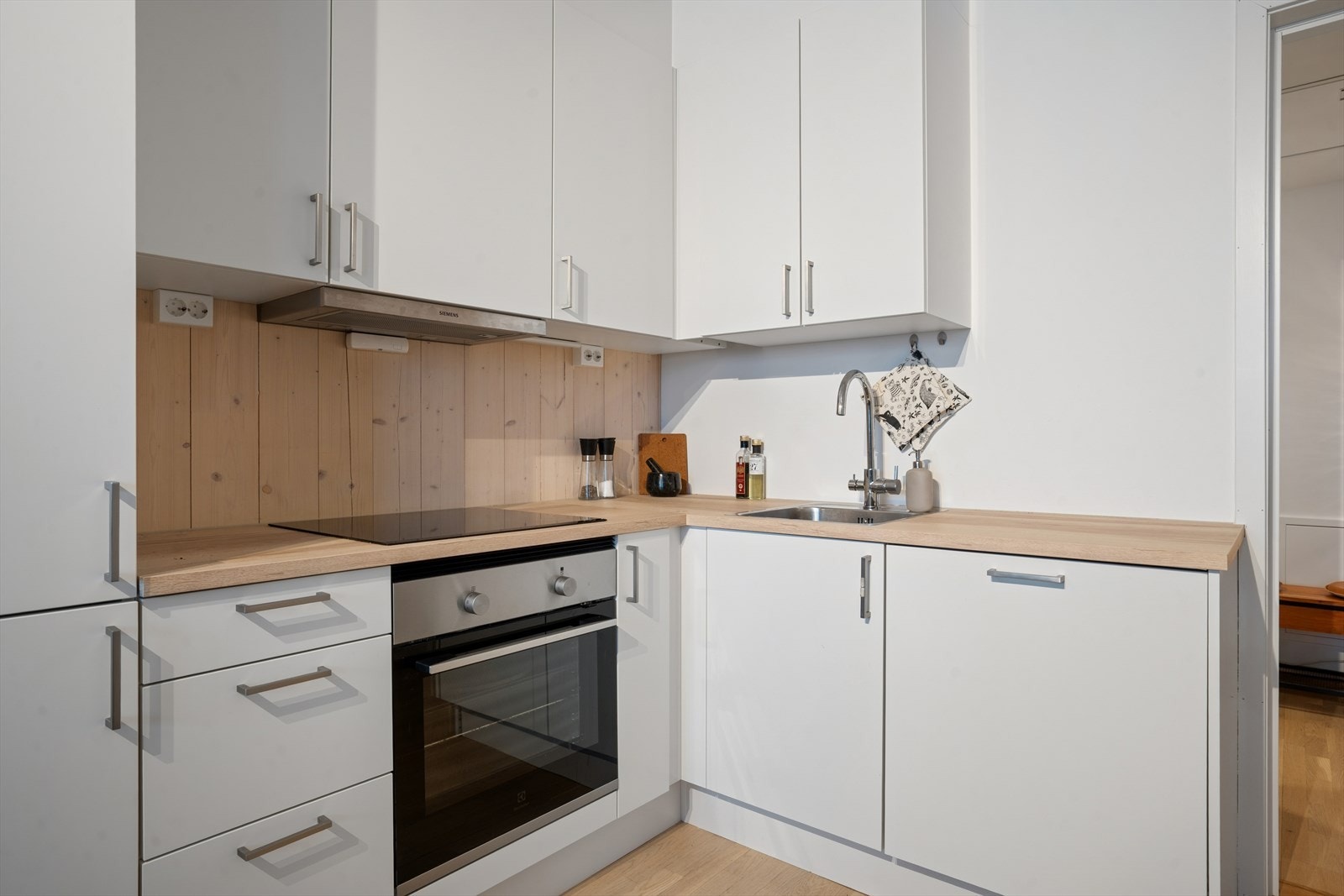 Tidløst HTH-kjøkken fra byggeåret, med slette, fabrikklakkerte fronter. Galleribilde