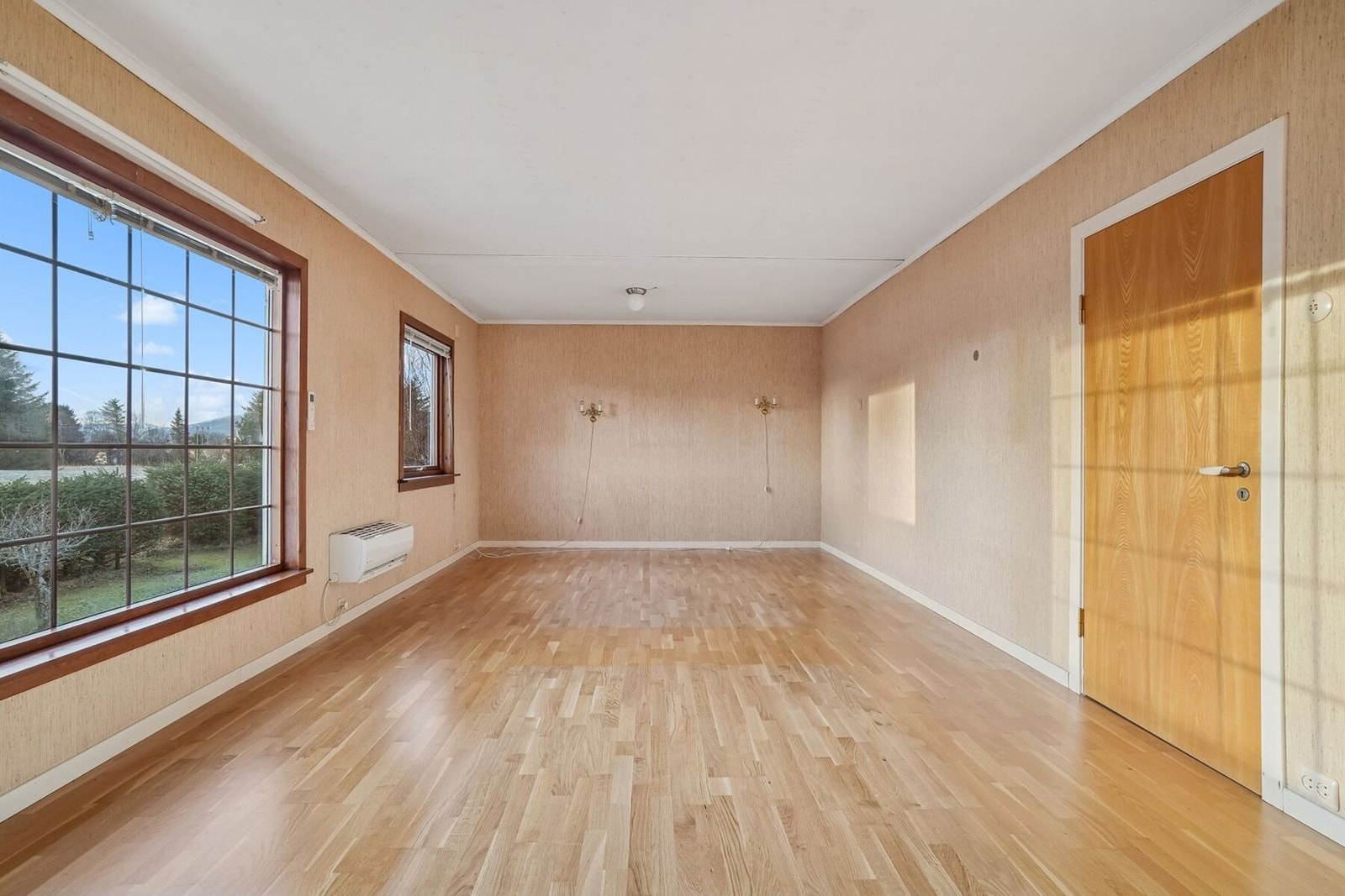 På stuen er det god plass til å møblere. Gulvoverflater av parkett, og på veggene er det tapet. Galleribilde