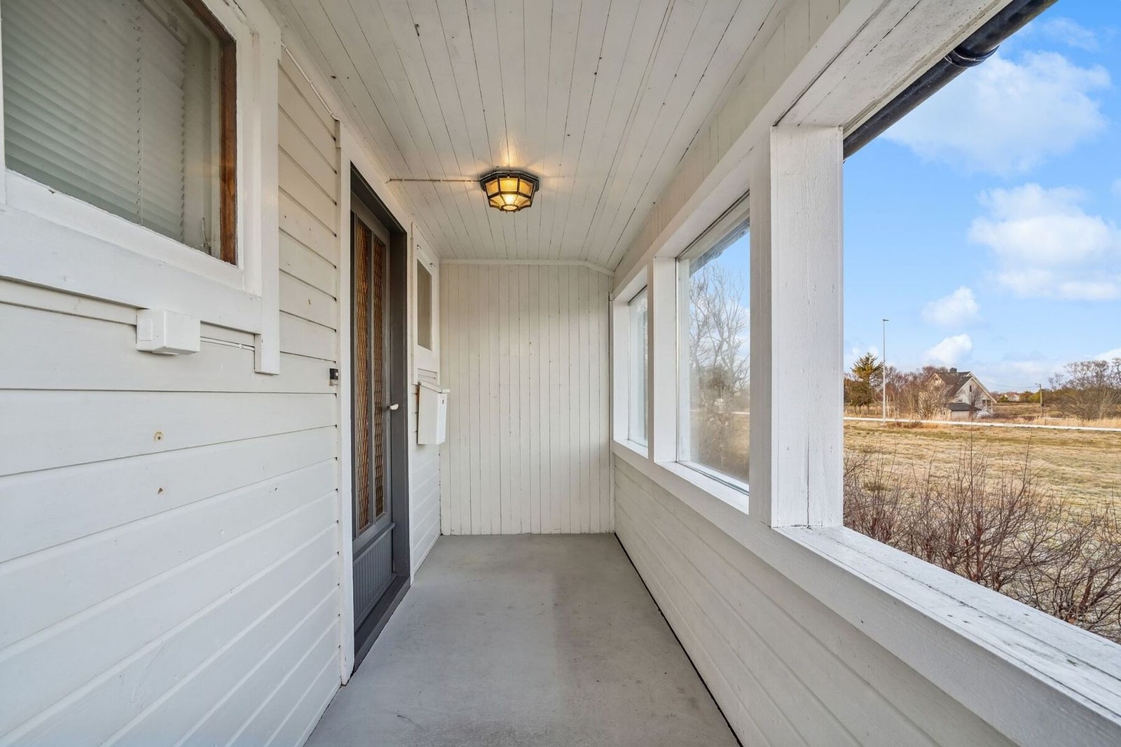 Inngangsparti/ veranda med overbygg. Det er støpt dekke og montert belysning i tak. Galleribilde