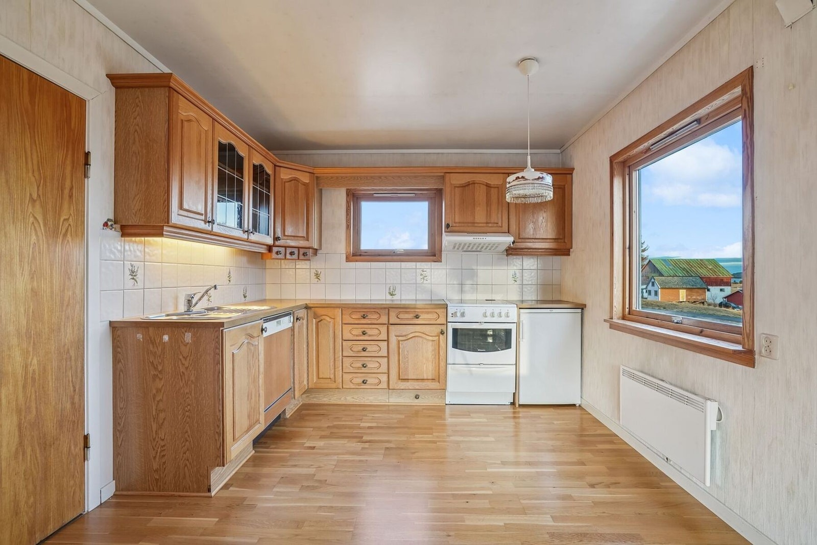 Kjøkkenet har eldre innredning med profilerte eikefronter. Benkeplate av laminat. Galleribilde