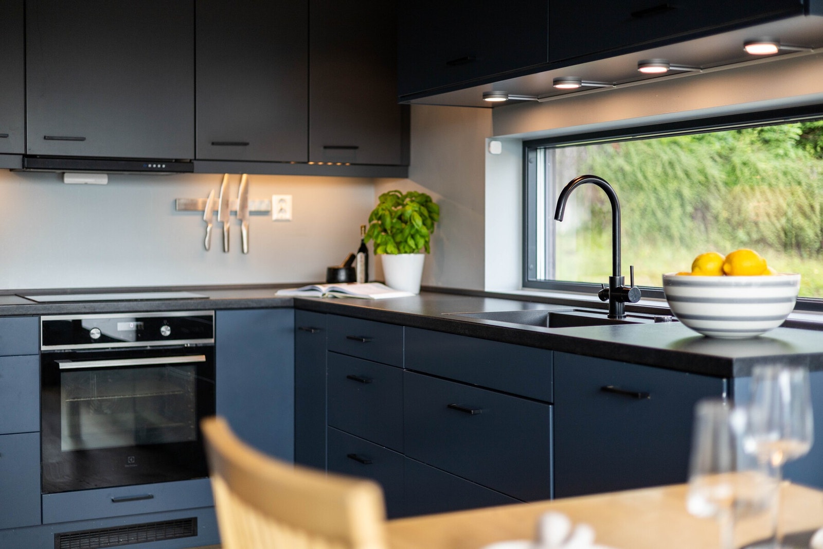 Funksjonell kjøkkenløsning med rikelig benkeplass og vindu over vasken som gir naturlig lys til matlagingen Galleribilde