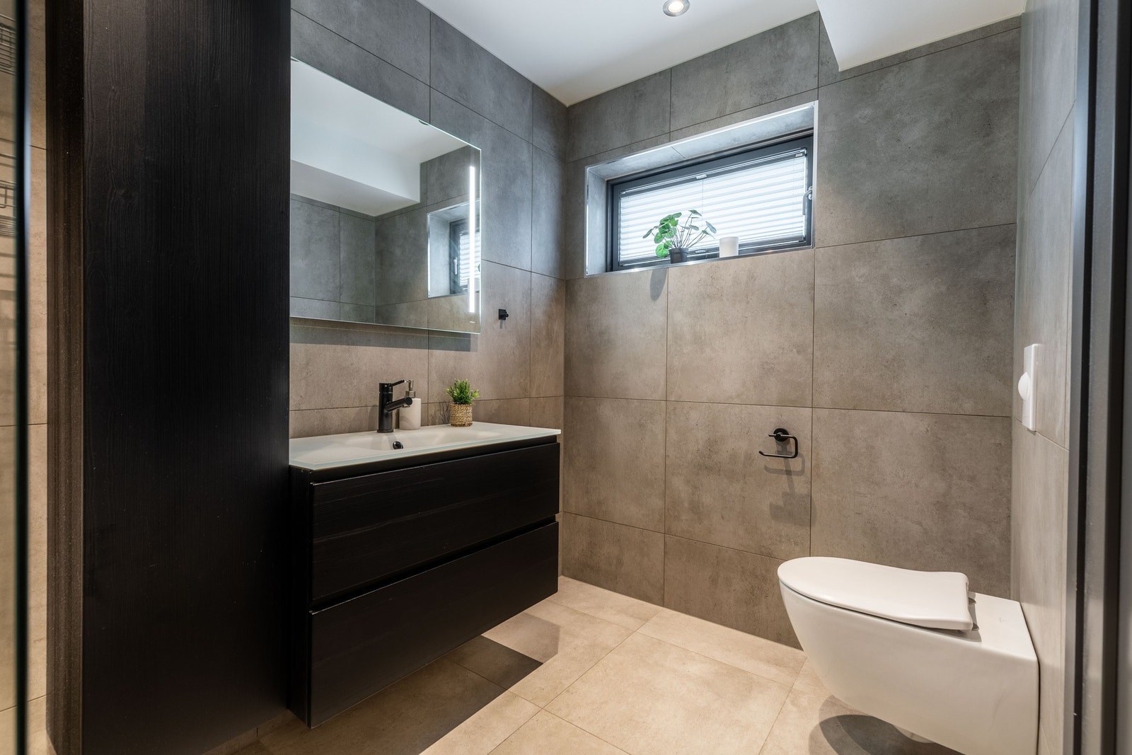 Elegant utførelse med mørke kontraster, integrert belysning i speil og moderne armaturer Galleribilde