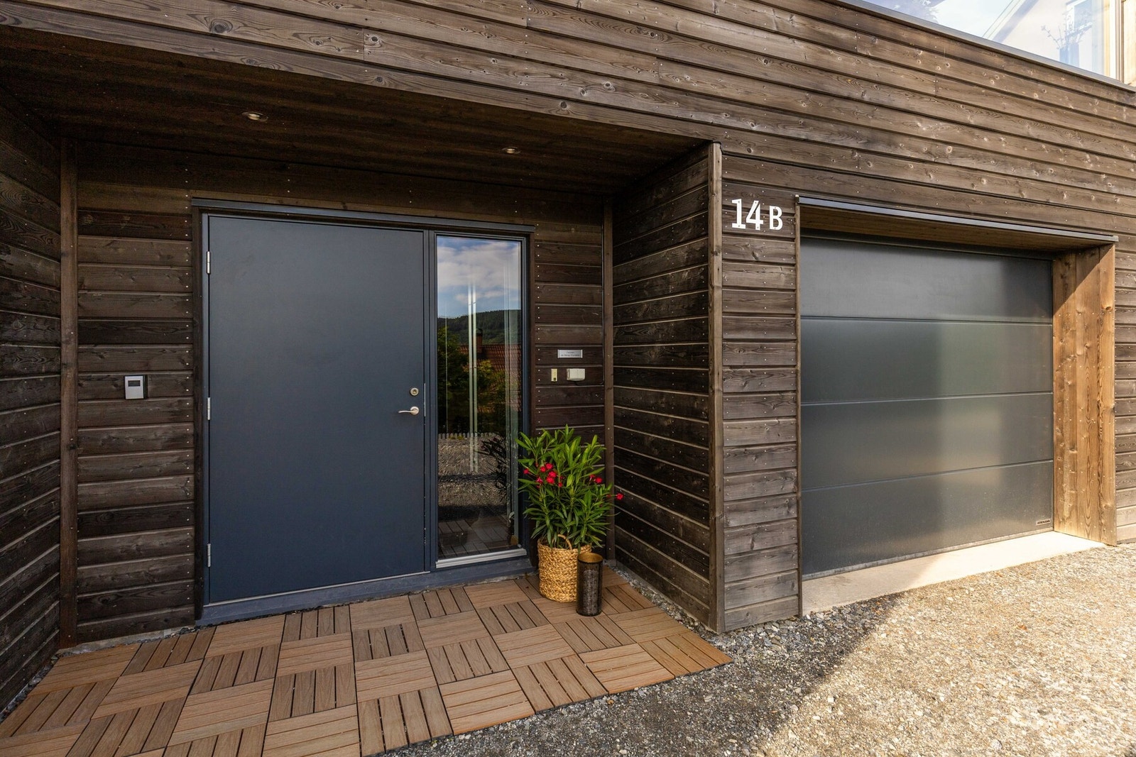 En innbydende inngang med stor dør og integrert garasje rett ved siden av Galleribilde