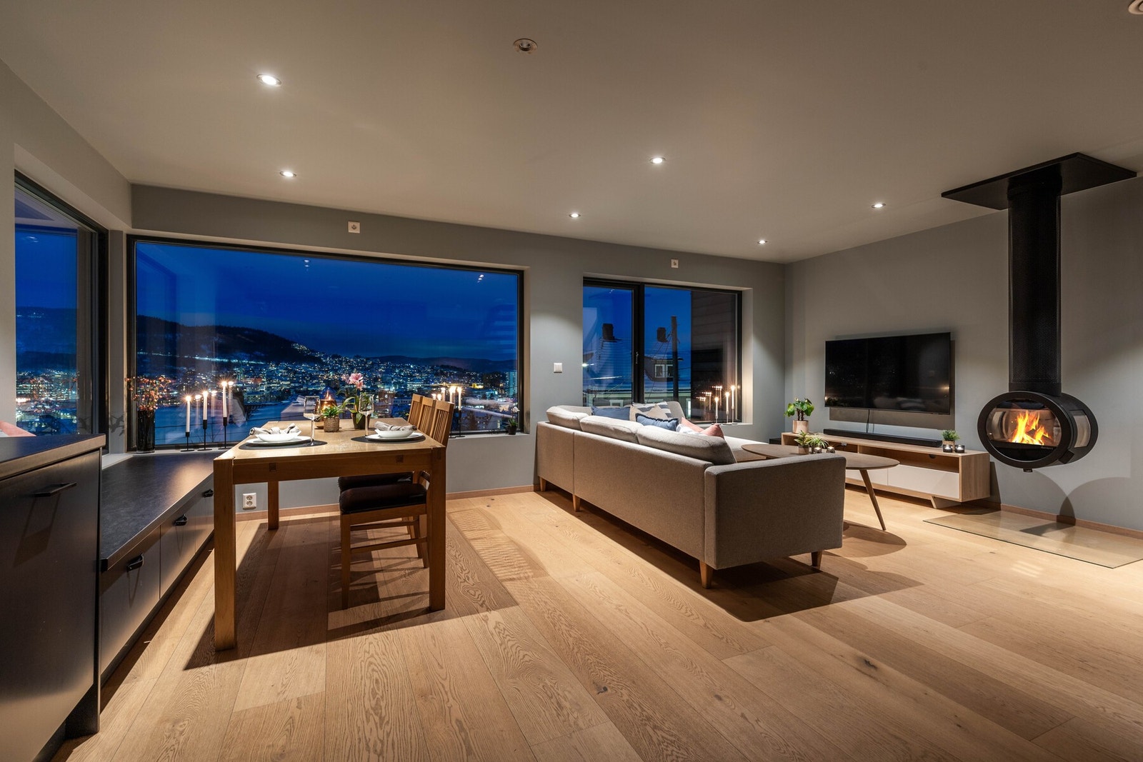 Stilren stue med åpen planløsning, lekker peisovn og god plass til både sofagruppe og spisestue Galleribilde