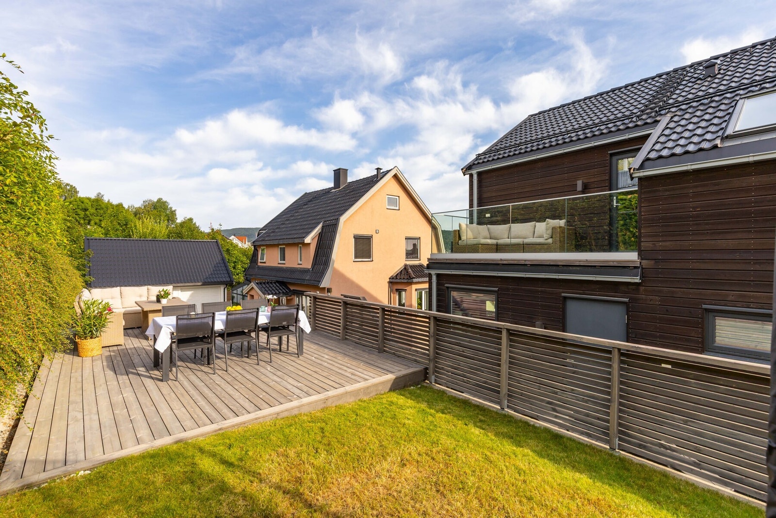 Terrasse og gressplen med rekkverk som gir en trygg skjerming for huset Galleribilde