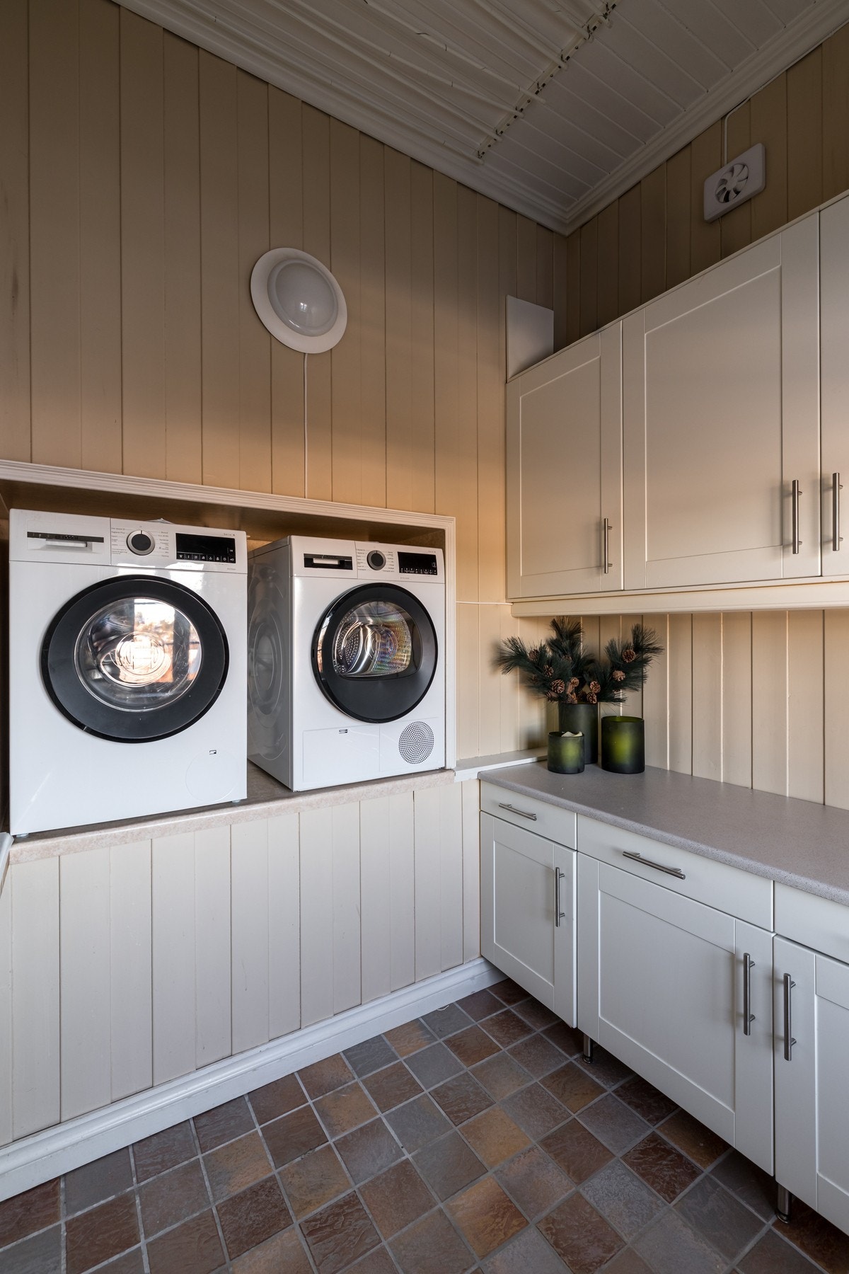 Praktisk vaskerom med direkte adkomst fra entréen, og smart nisjeløsning for vaskemaskin og tørketrommel i høyde. Galleribilde