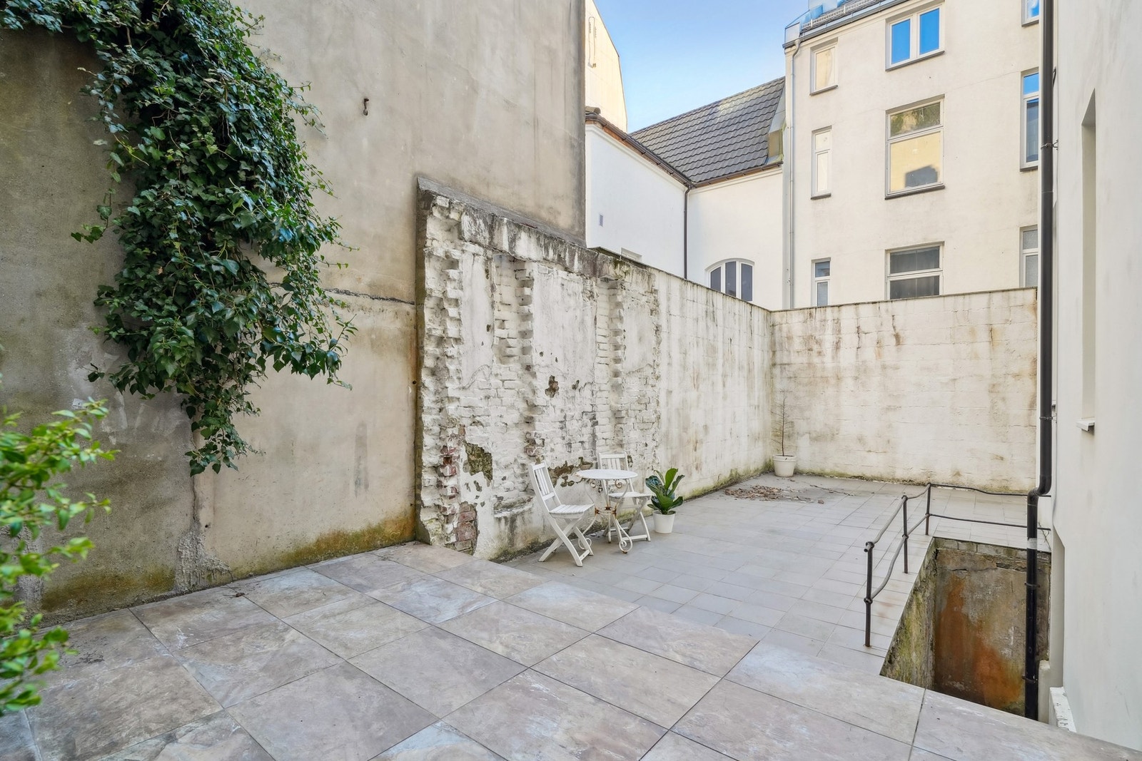 Koselig felles bakgård med plass til loungemøbler og beplantning i krukker. Galleribilde
