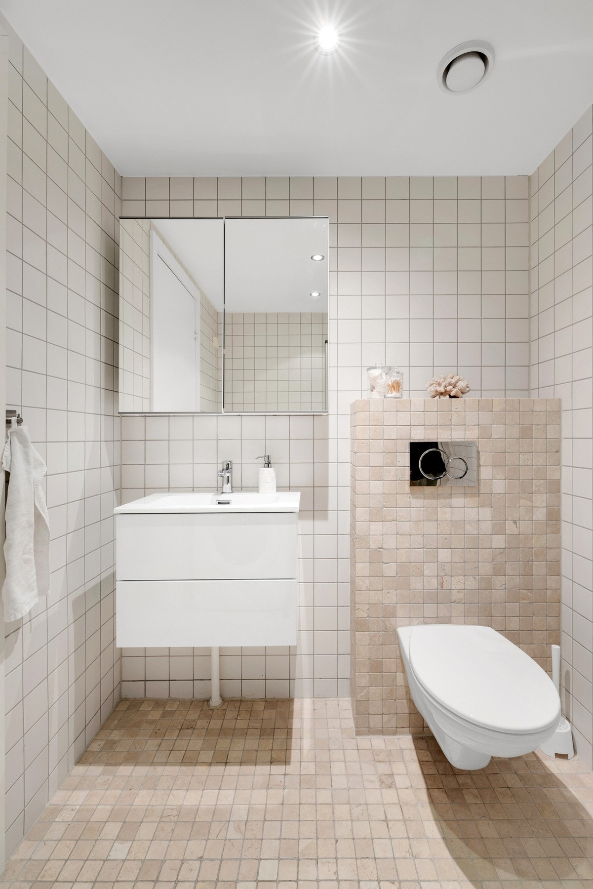 Flislagt bad i lyse, tidløse farger. Vegghengt toalett og stilren servantinnredning gir et ryddig og elegant uttrykk. Galleribilde