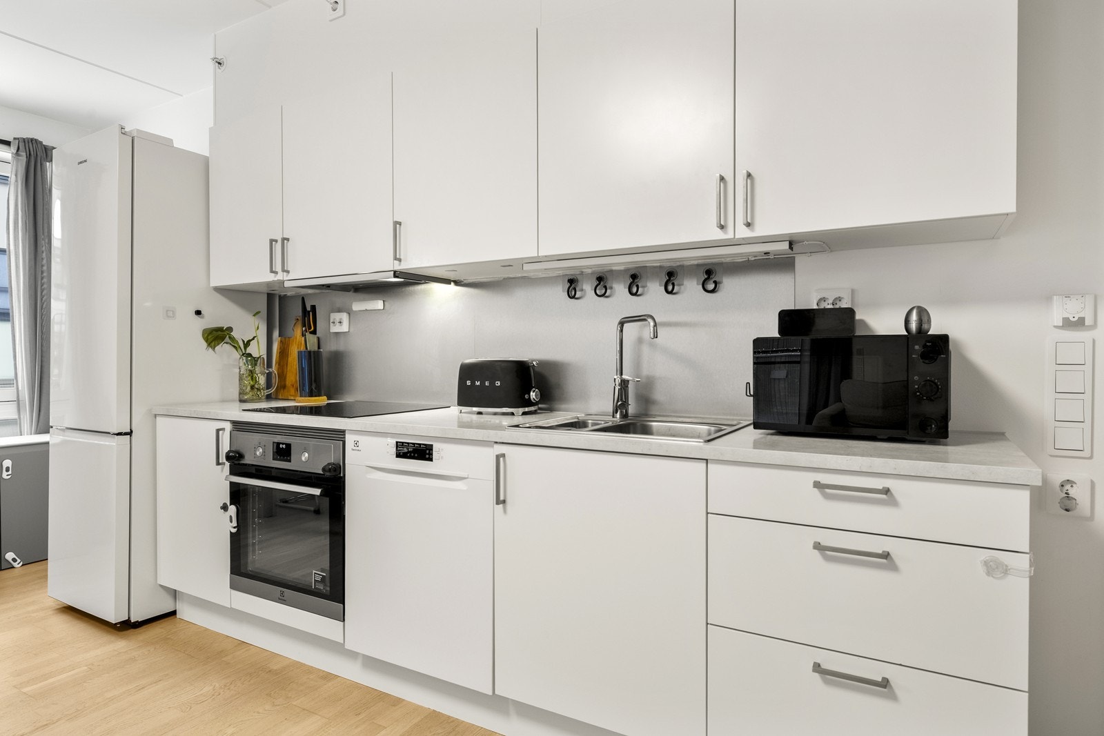 Det er frittstående oppvaskmaskin, kjøleskap og frys på kjøkkenet. Galleribilde