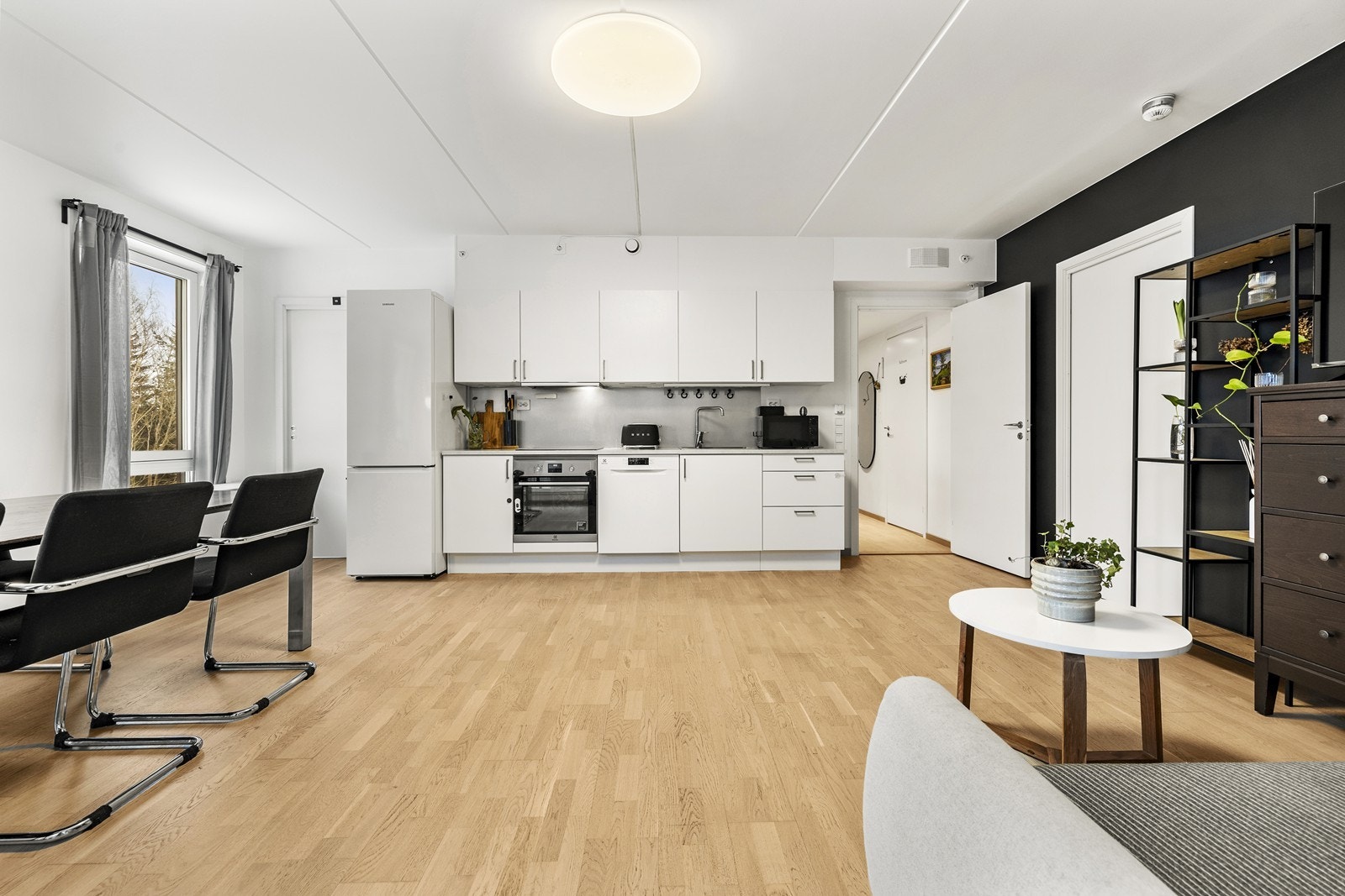 Den åpne løsningen mellom stue og kjøkken gir en sosial og luftig atmosfære. Galleribilde