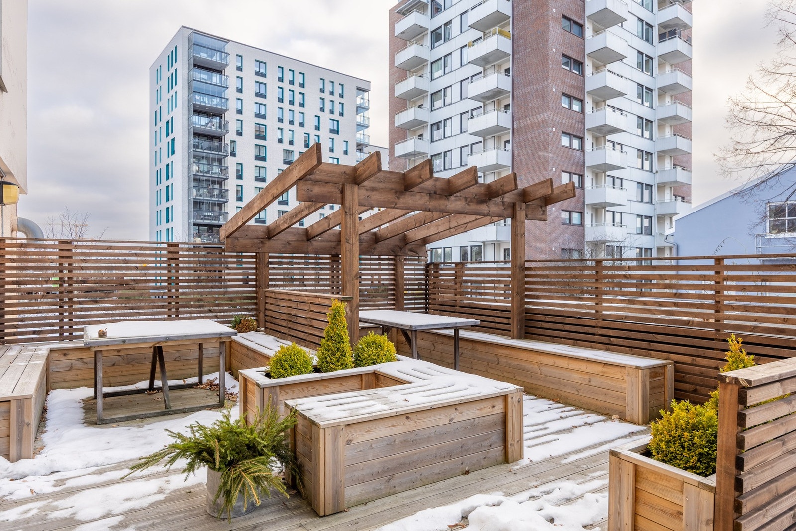 Felles terrasse med flere sittegrupper og pergola. Galleribilde