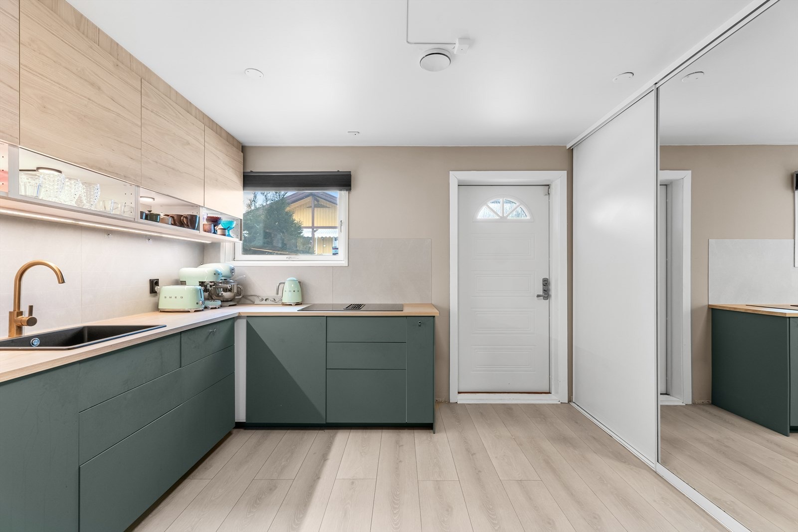 Du ønskes velkommen inn i en praktisk entré med integrert skyvedørsgarderobe og adkomst til boligens åpne stue- og kjøkkenløsning. Galleribilde