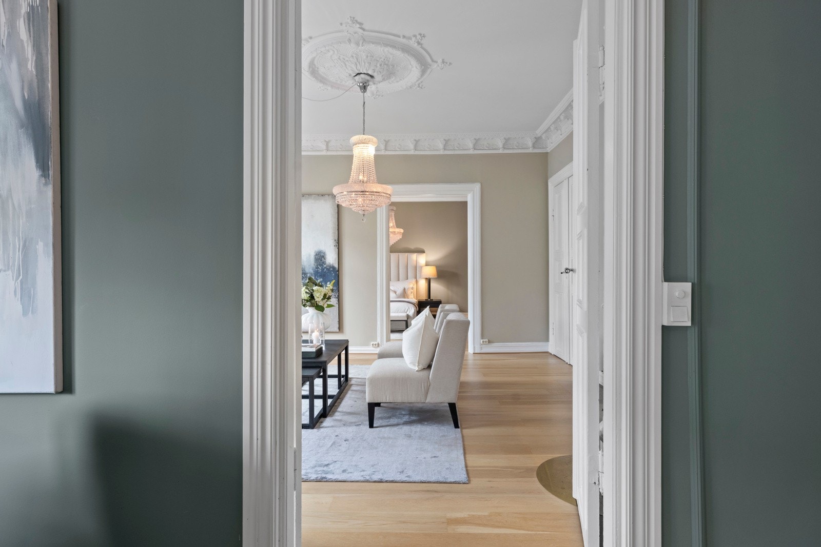 Vi beveger oss videre inn i en stue som virkelig tar pusten fra deg - lysekroner, rosetter og en kakkelovn som setter prikken over i-en. Galleribilde