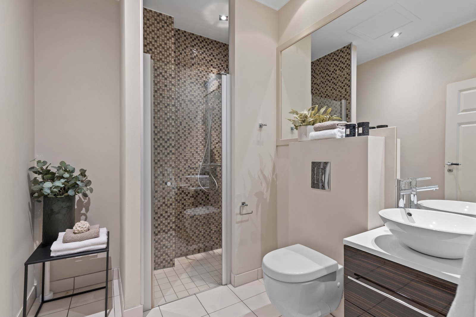 Fra soverommet trer vi inn på et eksklusivt masterbad med mørk innredning og flislagte flater. Galleribilde