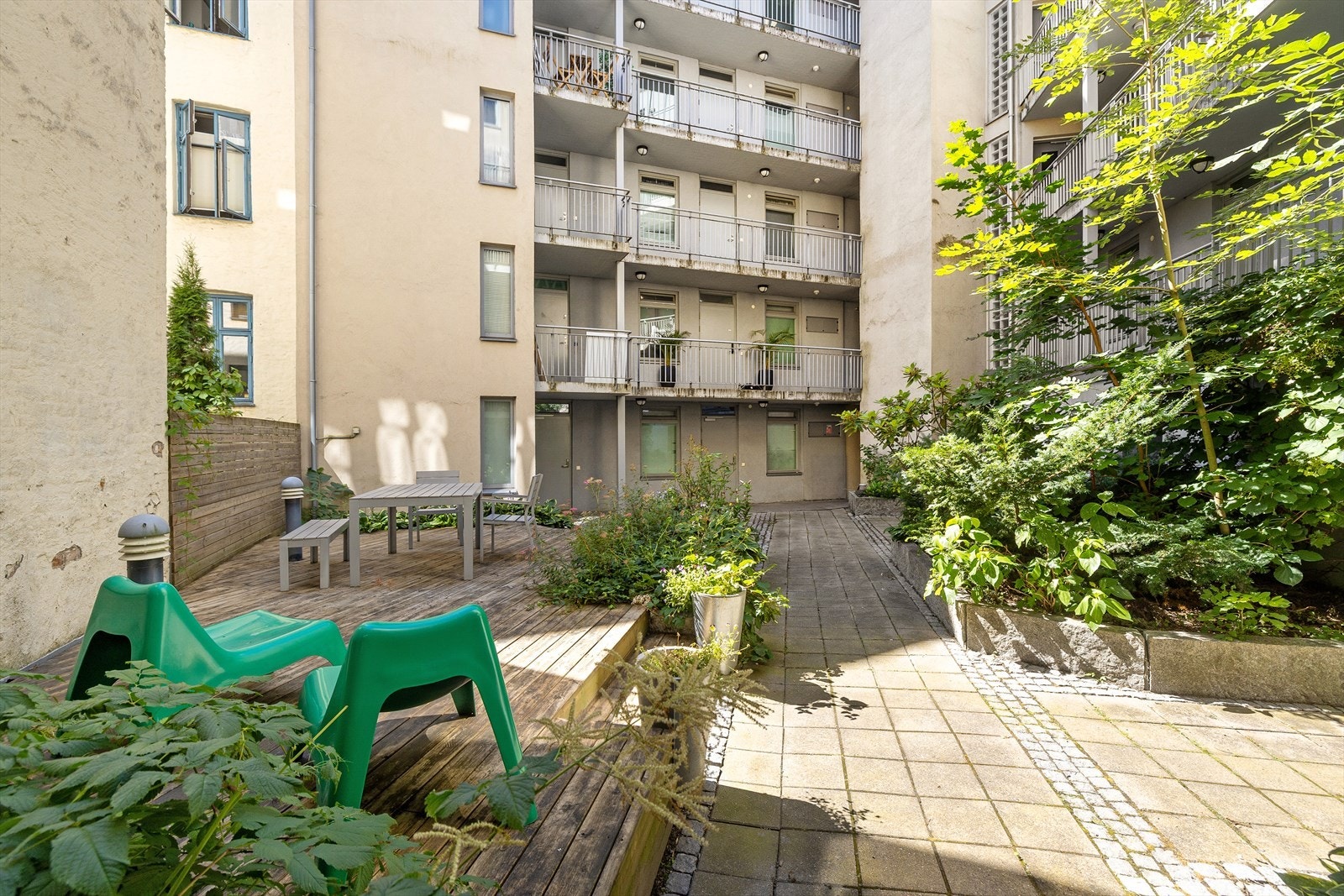 Felles gårdsrom med beplantning gir et hyggelig uteområde for beboerne. Galleribilde