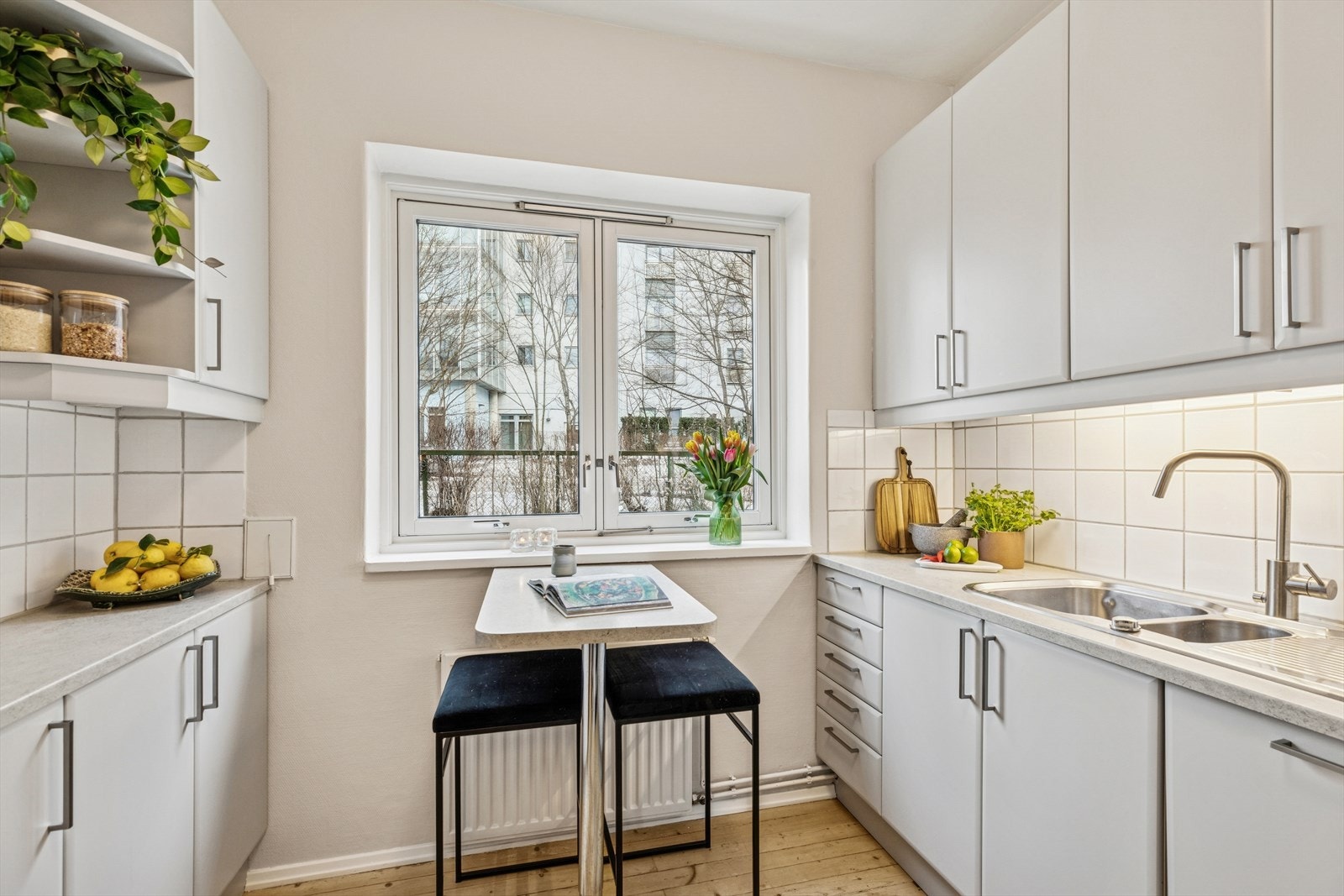 Lyst og funksjonelt kjøkken med smart spiseplass ved vinduet - perfekt for rolige morgener og raske måltider. Galleribilde