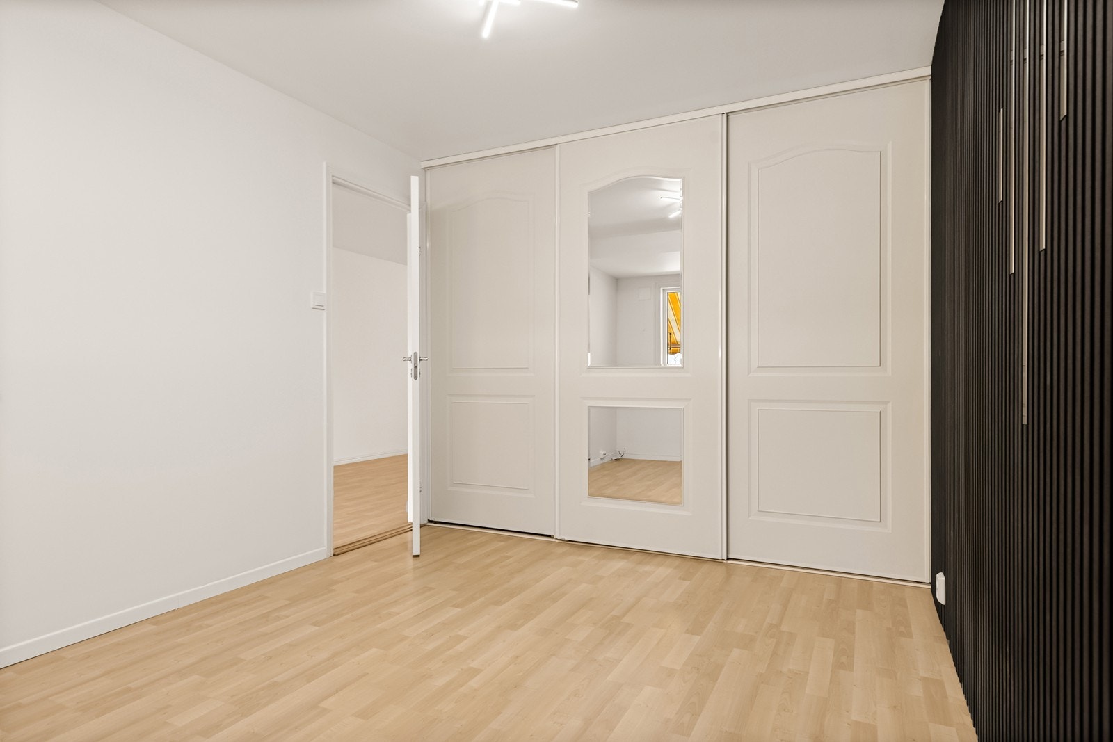 En stor skyvedørsgarderobe med speilfronter gir rikelig med oppbevaringsplass. Galleribilde