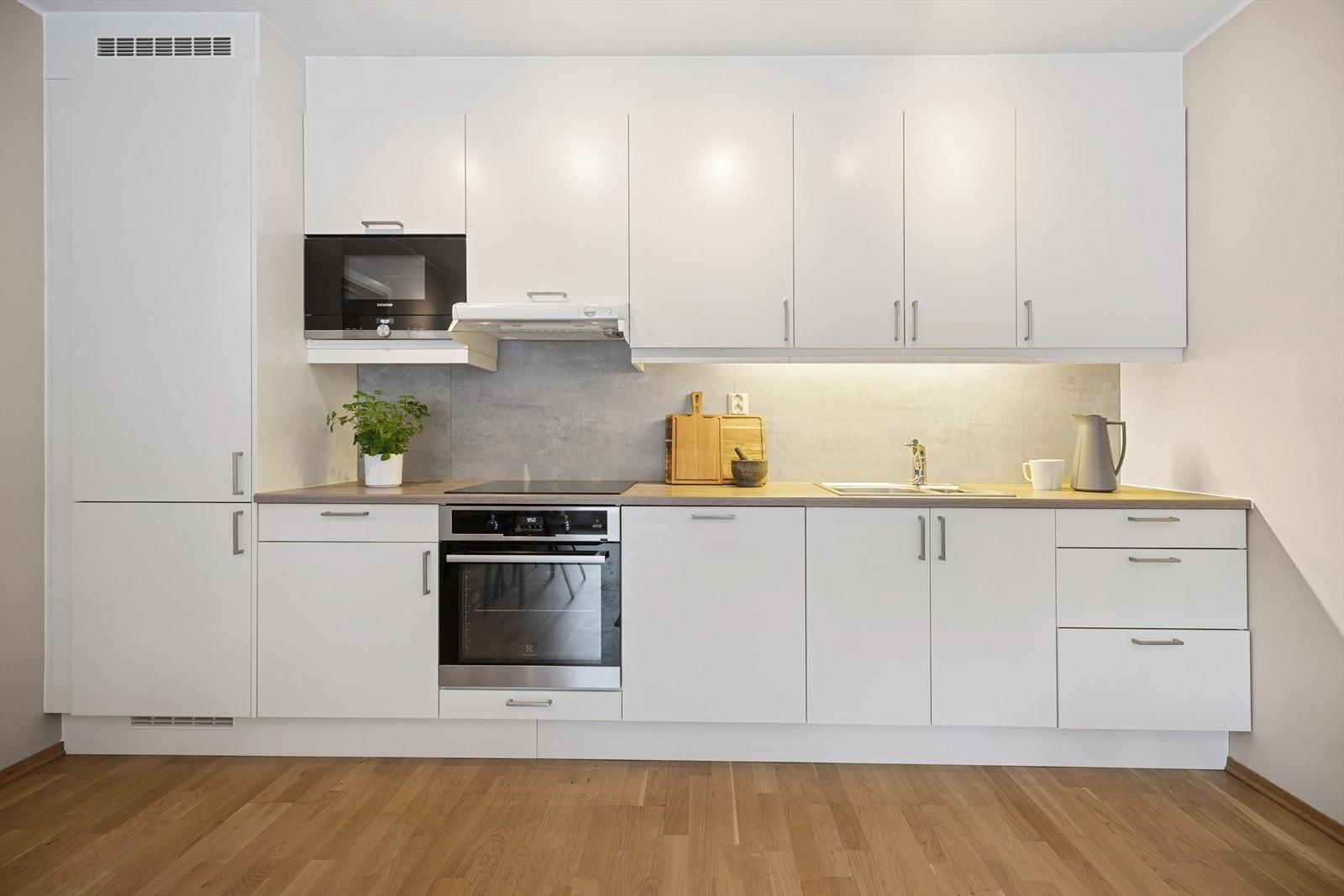 Kjøkkenet er utstyrt med integrerte hvitevarer som ovn, kjøl/frys og oppvaskmaskin, samt spjellventilator over kokesone. Galleribilde