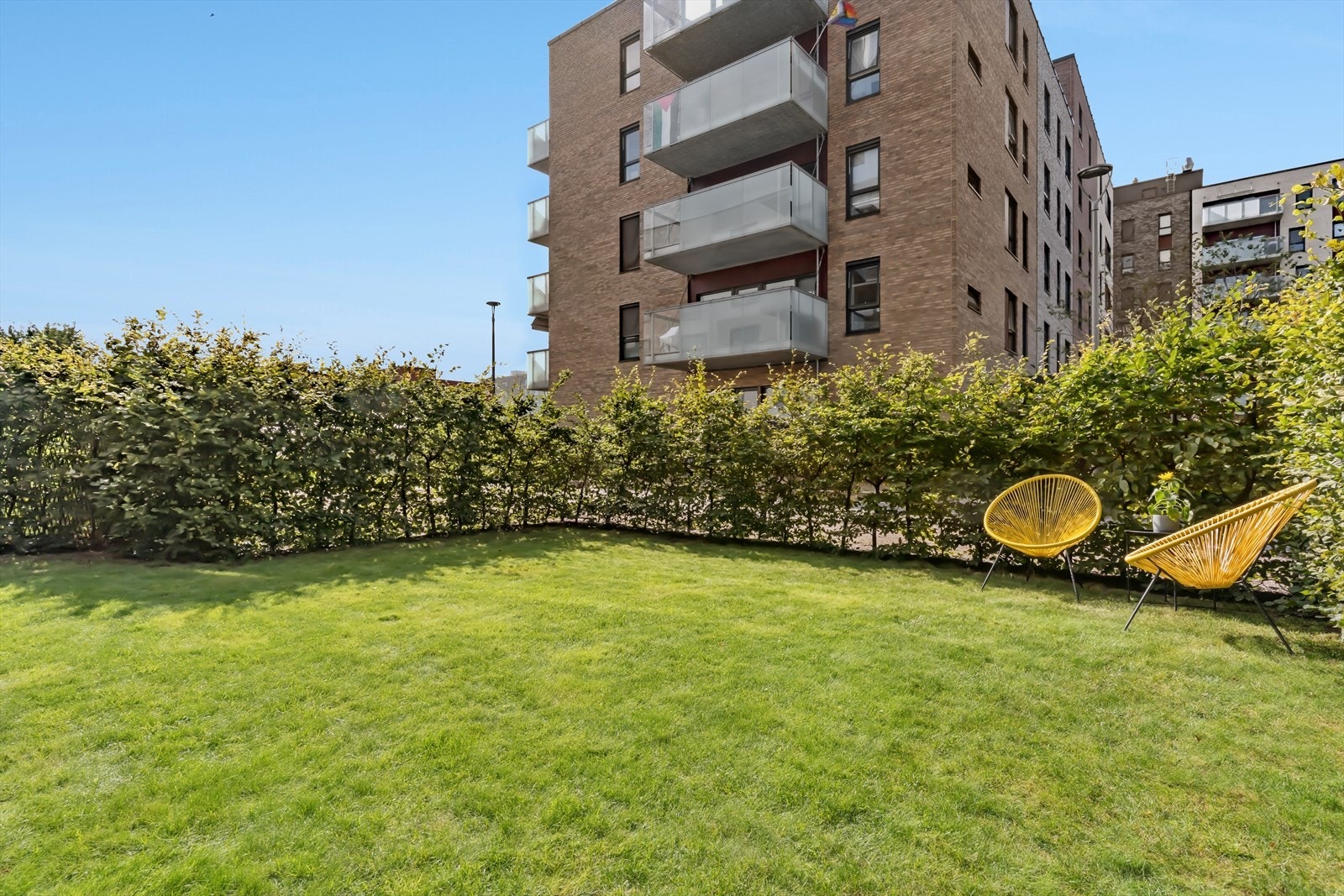 Stor og grønn gressplen med hekk rundt som gir god skjerming sommerhalvåret. Galleribilde