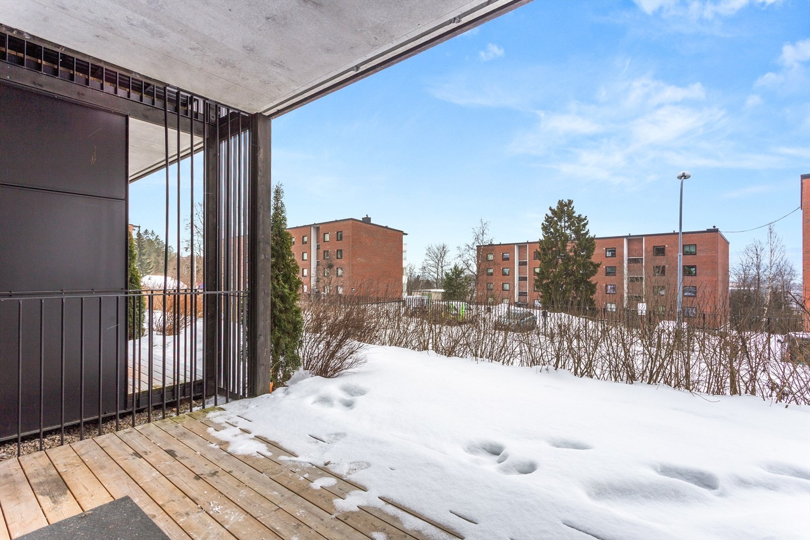 Utgang fra stue til en hyggelig nordvestvendt terrasse på ca. 8 m² med utsikt og gode solforhold. Her er det tregulv og god plass til utemøbler. Galleribilde