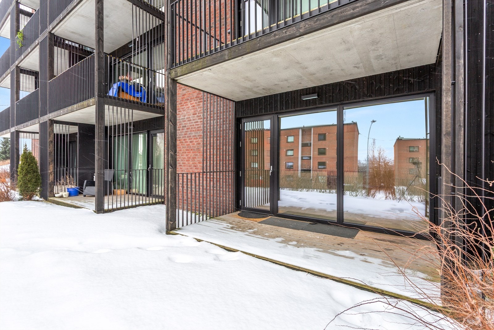 Utgang fra stue til en hyggelig nordvestvendt terrasse på ca. 8 m² med utsikt og gode solforhold. Her er det tregulv og god plass til utemøbler. Galleribilde