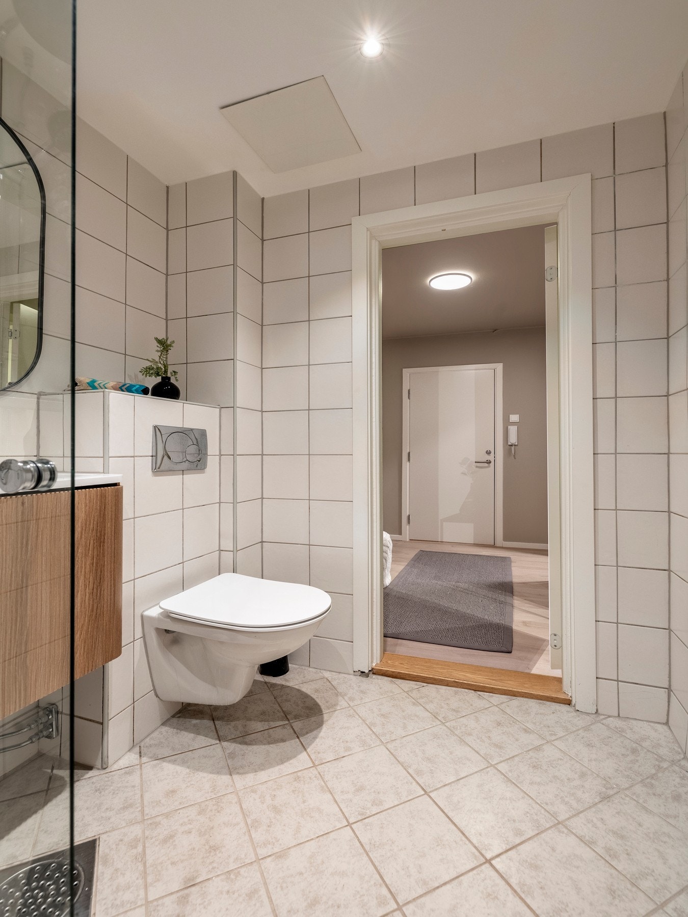 Innredningen består av servantinnredning, speil på vegg over servant, veggmontert toalett, svingbar dusjvegg og opplegg for vaskemaskin. Galleribilde